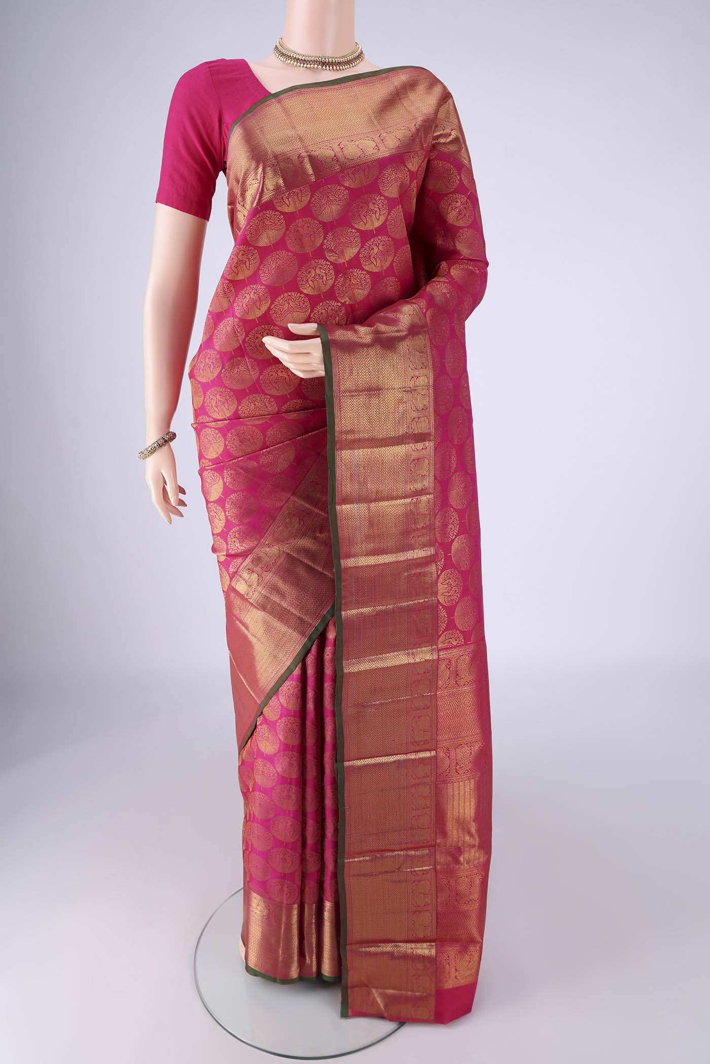 Rani Pink Kanchipuram Silk Saree with Zari Brocade on the body and Zari Border.  displayed on a mannequin