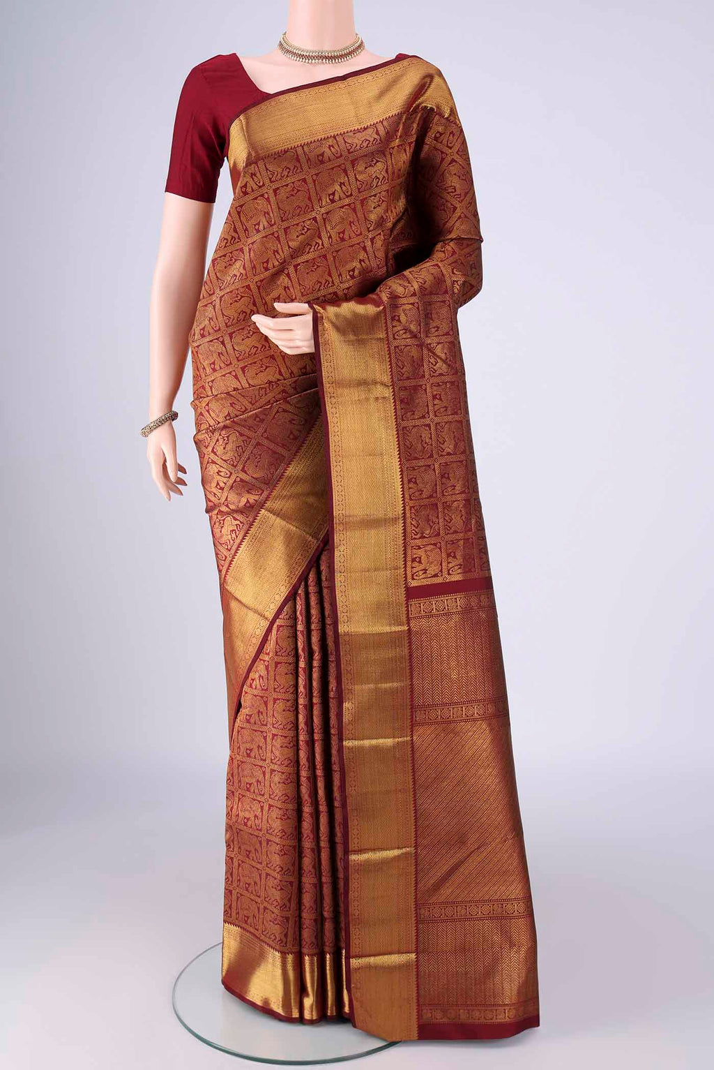 Maroon Kanchipuram Silk Saree with Zari Brocade on the body and Zari Border.  displayed on a mannequin