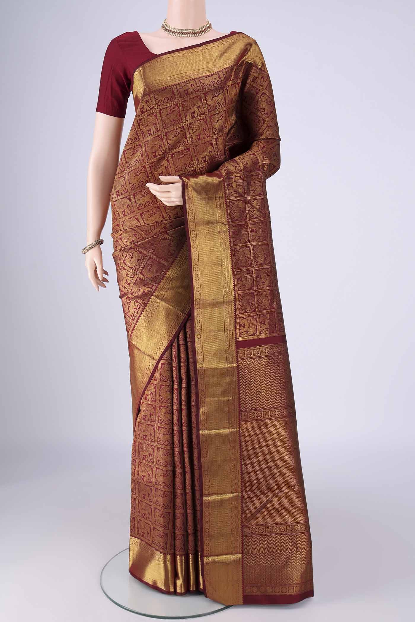Maroon Kanchipuram Silk Saree with Zari Brocade on the body and Zari Border.  displayed on a mannequin