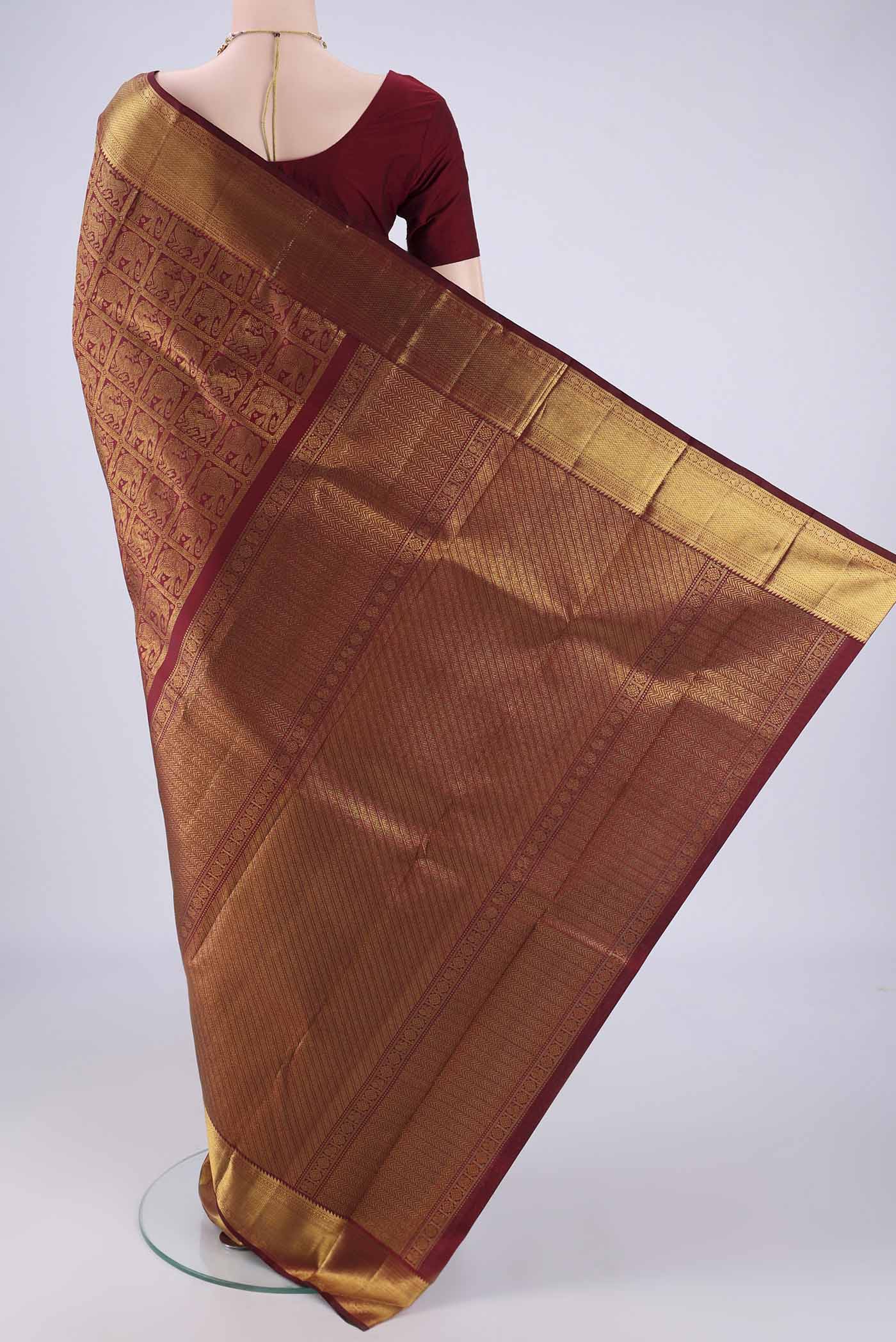 Flat view of Maroon Kanchipuram Silk Saree with Zari Brocade on the body and Zari Border. 