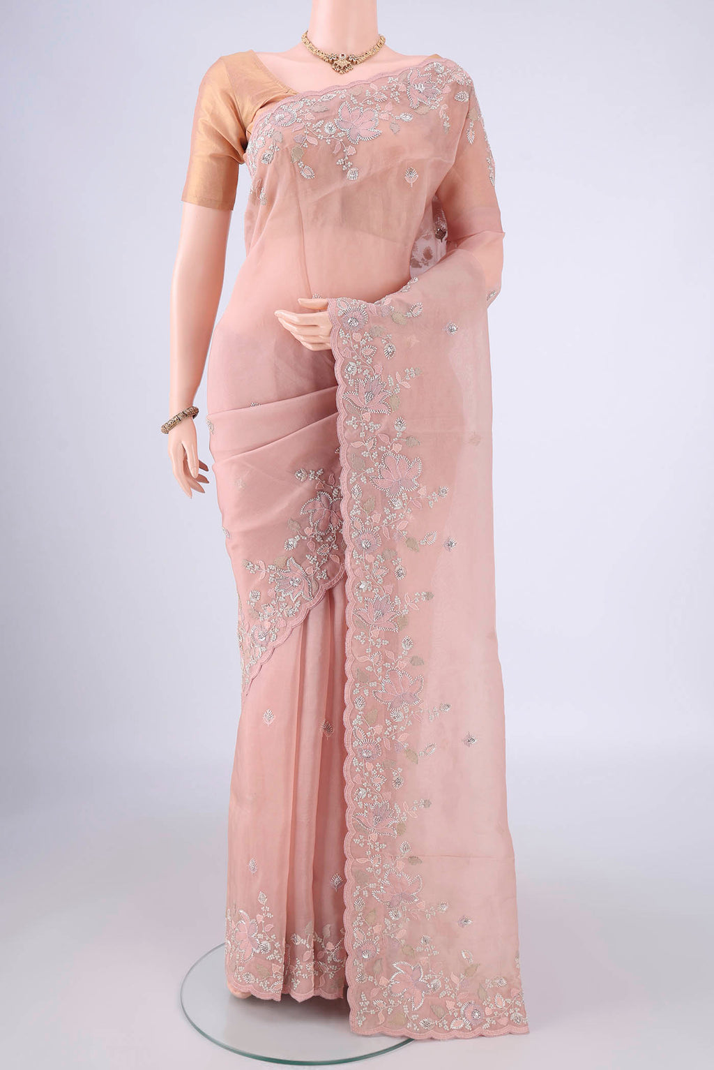 Rose Gold Organza Silk Saree with Embroidery on the body and Embroidery Border.  displayed on a mannequin