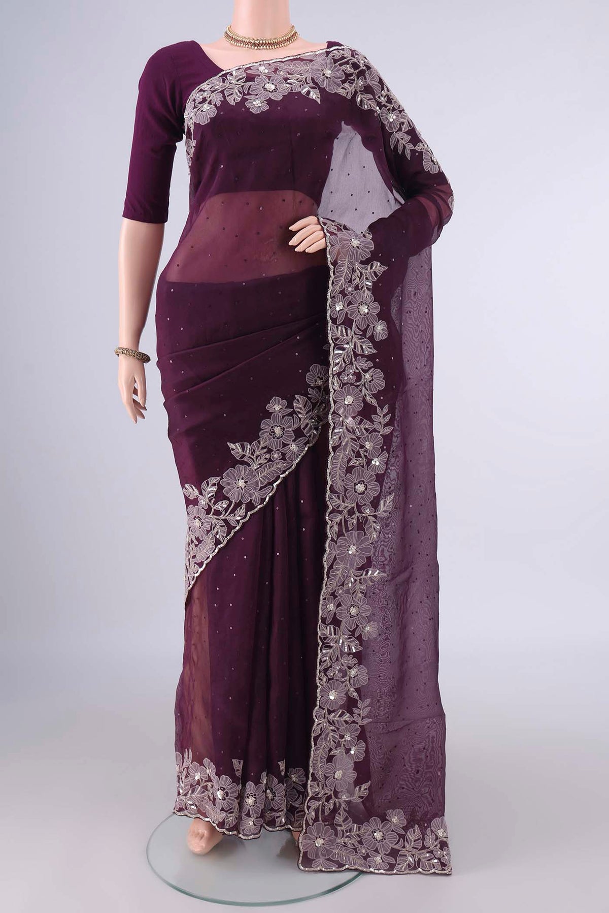 Burgundy Organza Saree with Embroidery on the body and Embroidery Border.  displayed on a mannequin