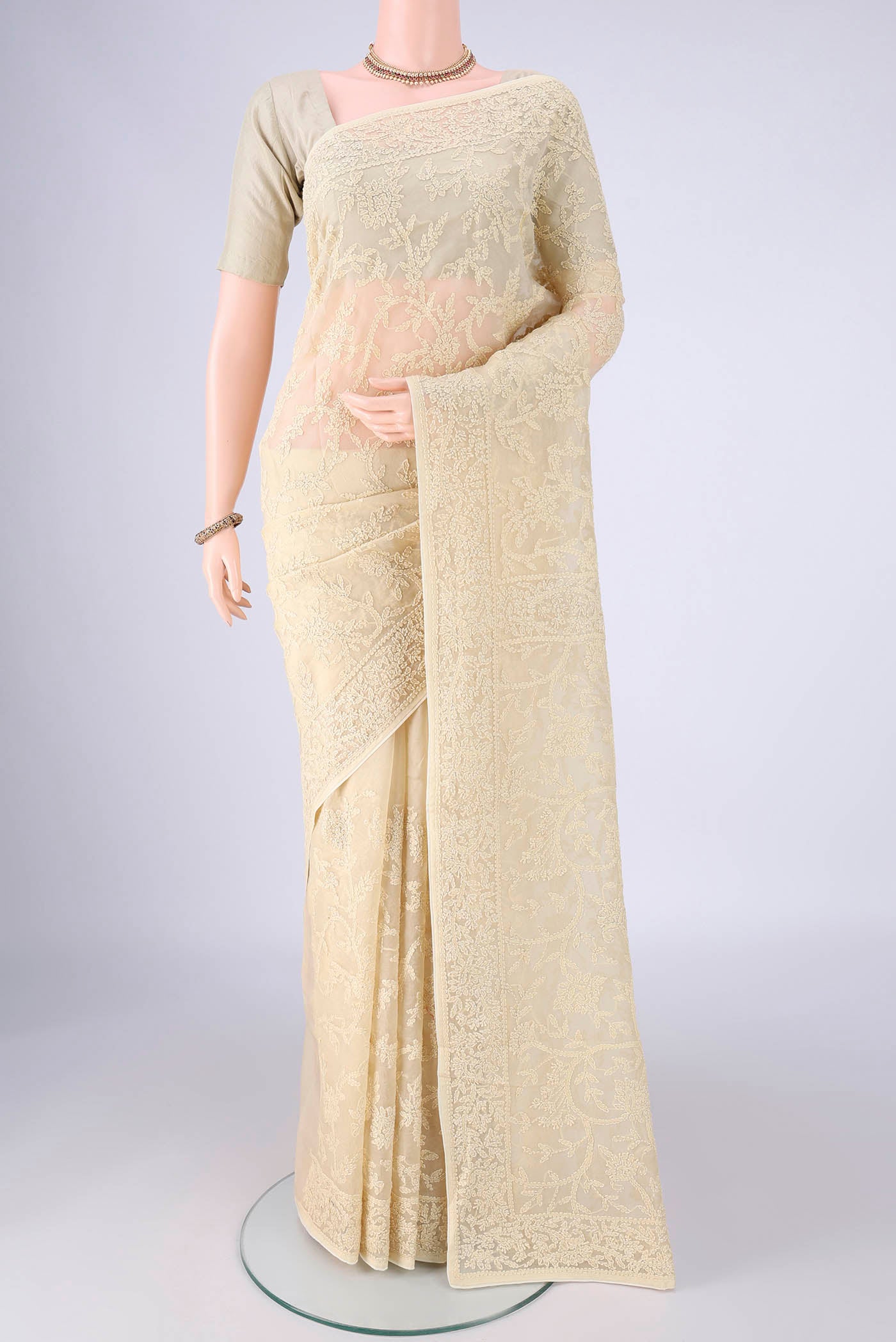 Beige Organza Silk Saree with Embroidery on the body and Thread Border.  displayed on a mannequin