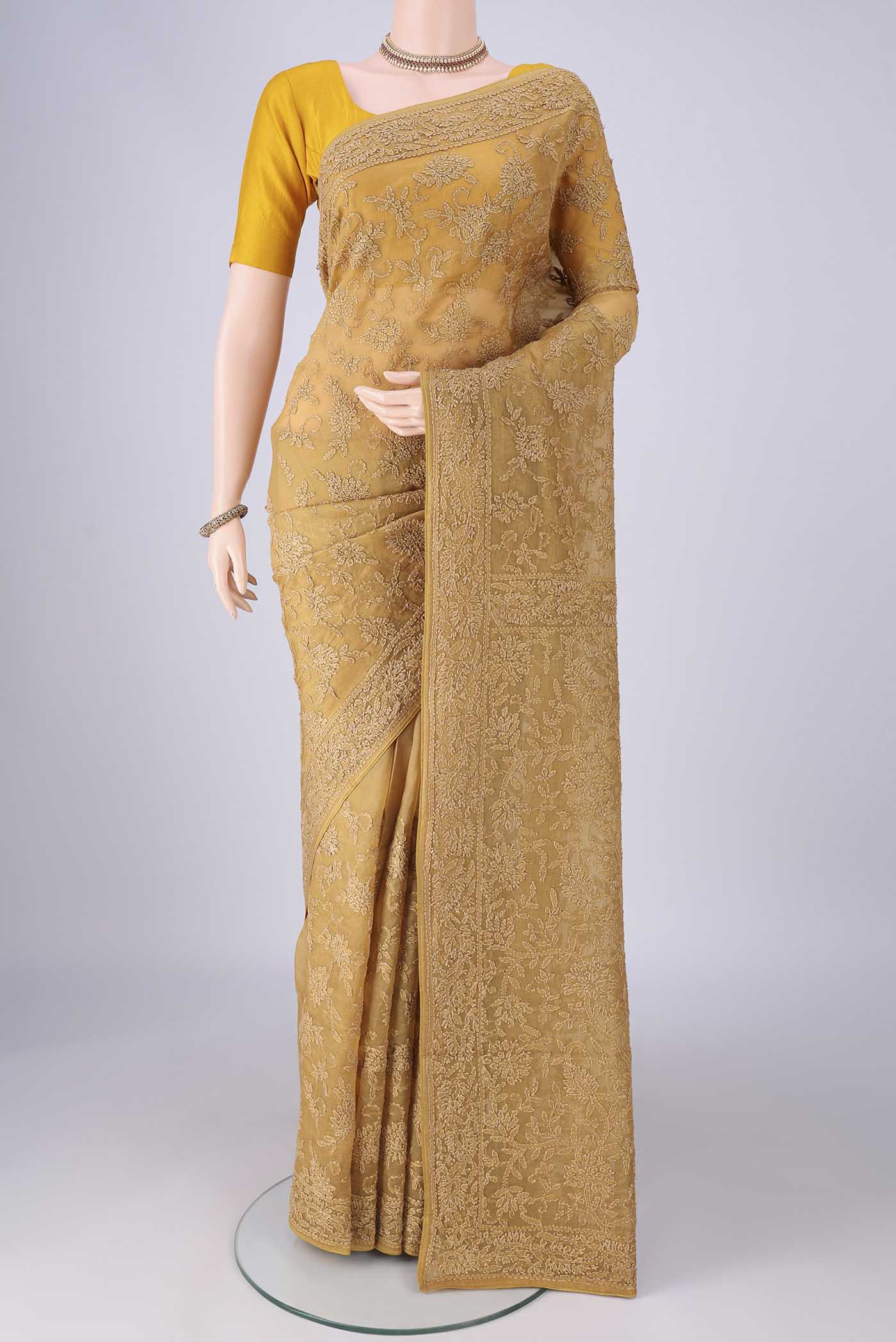 Mustard Organza Silk Saree with Embroidery on the body and Embroidery Border.  displayed on a mannequin
