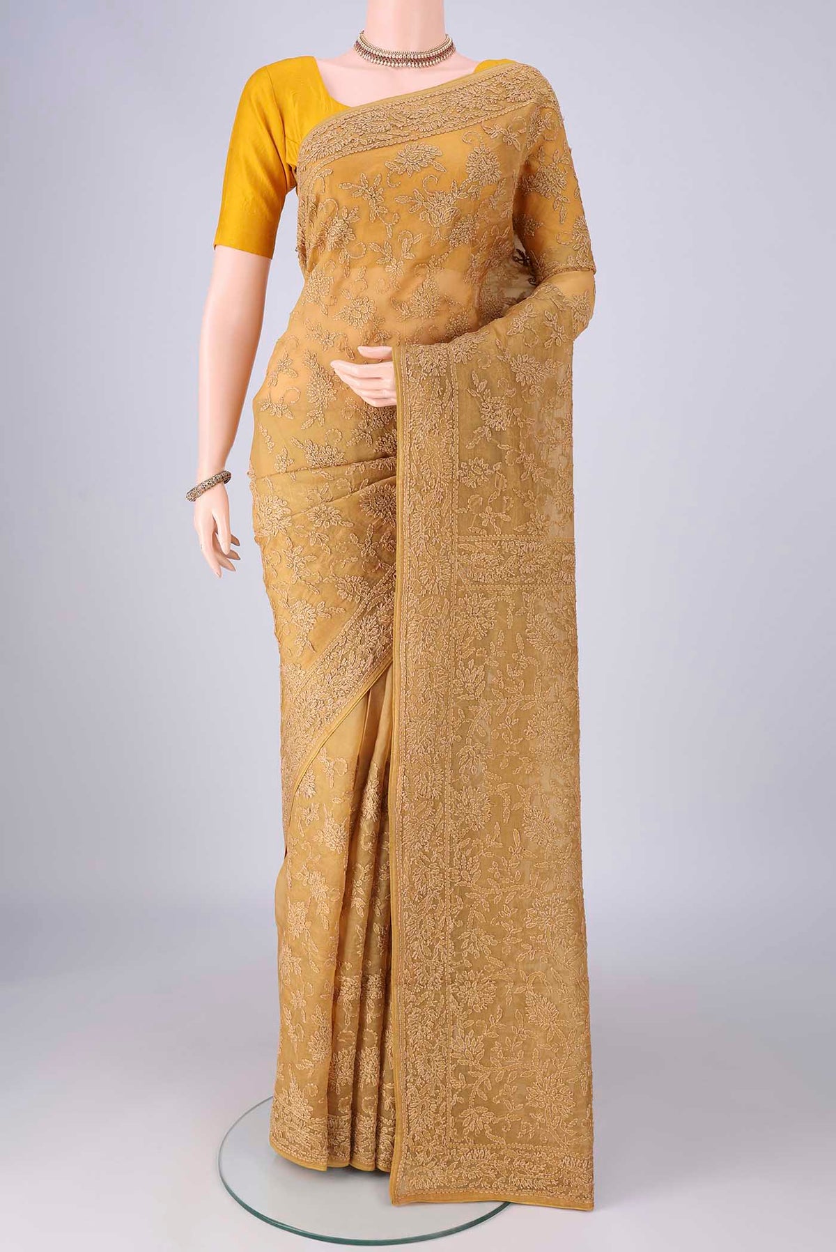Mustard Organza Silk Saree with Embroidery on the body and Embroidery Border.  displayed on a mannequin
