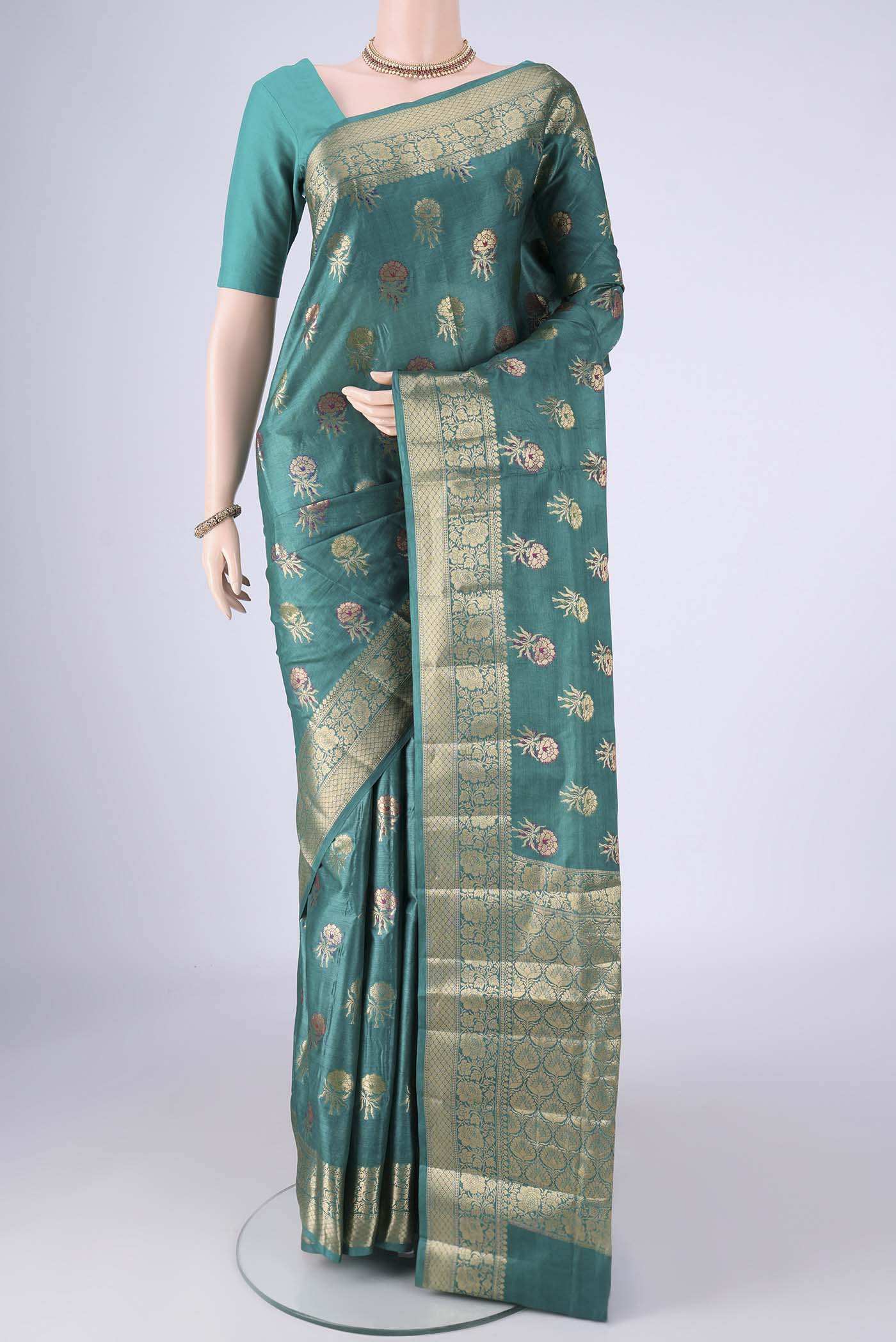 Sea Green Banarasi Tussar Silk Saree with Zari And Thread Butta on the body and Zari Border.  displayed on a mannequin