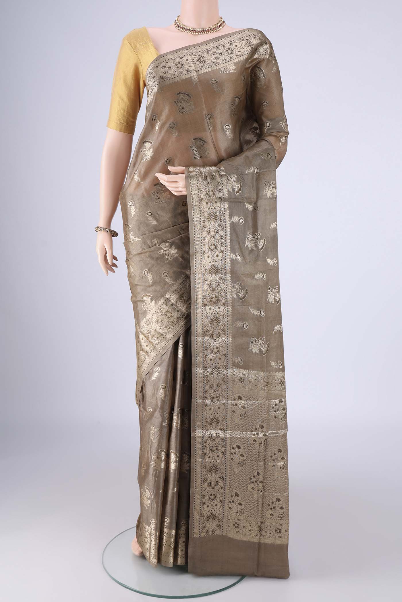 Dark Beige Banarasi Tussar Silk Saree with Zari And Thread Butta on the body and Zari Border.  displayed on a mannequin