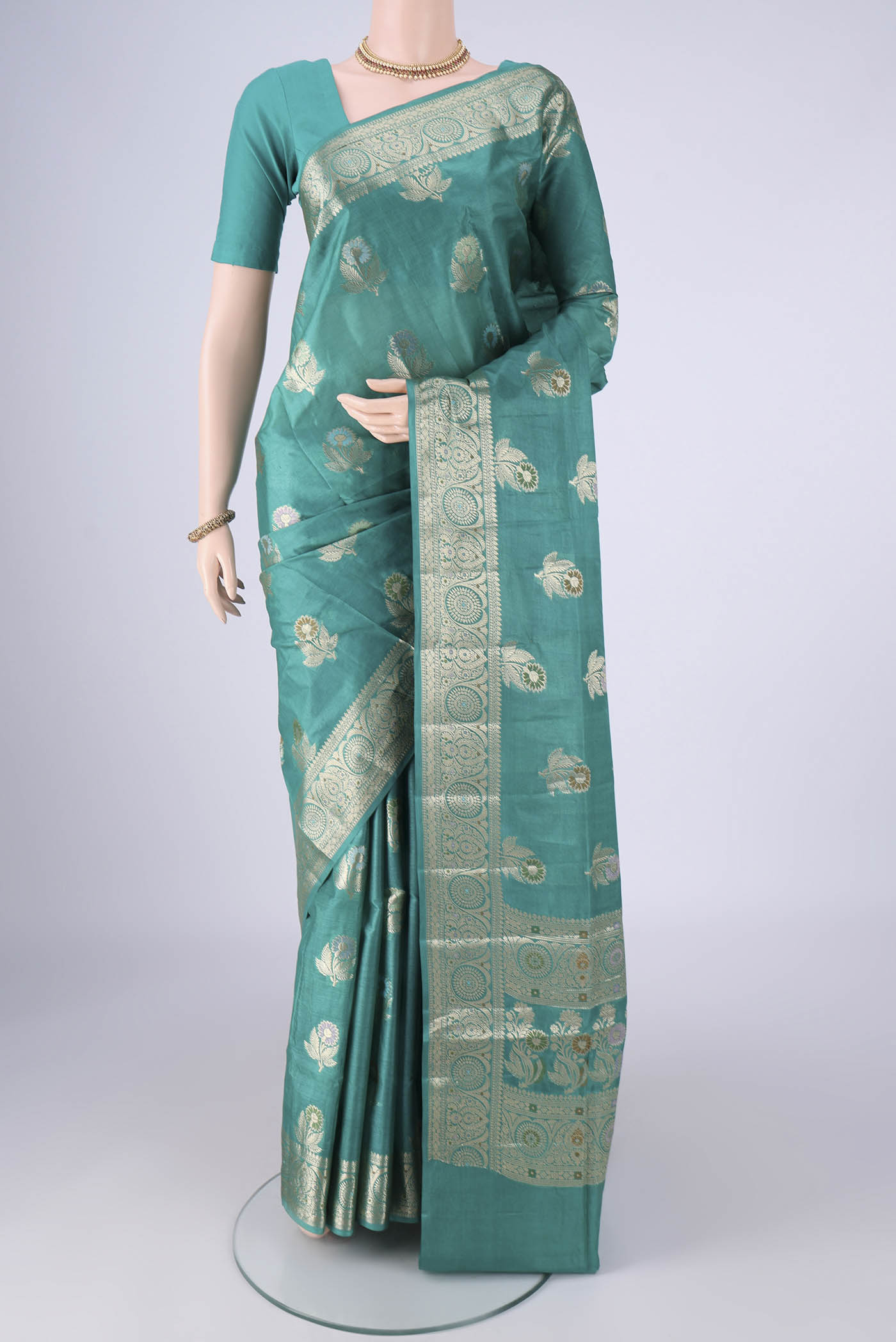 Turquoise Banarasi Tussar Silk Saree with Zari And Thread Butta on the body and Zari Border.  displayed on a mannequin