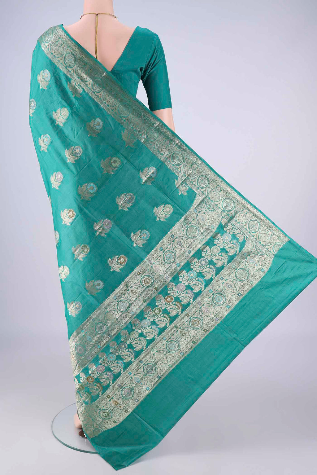 Flat view of Turquoise Banarasi Tussar Silk Saree with Zari And Thread Butta on the body and Zari Border. 