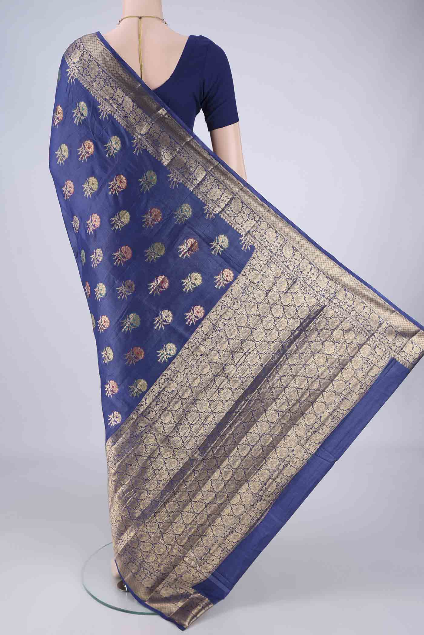 Flat view of Blue Banarasi Tussar Silk Saree with Zari And Thread Butta on the body and Zari Border. 
