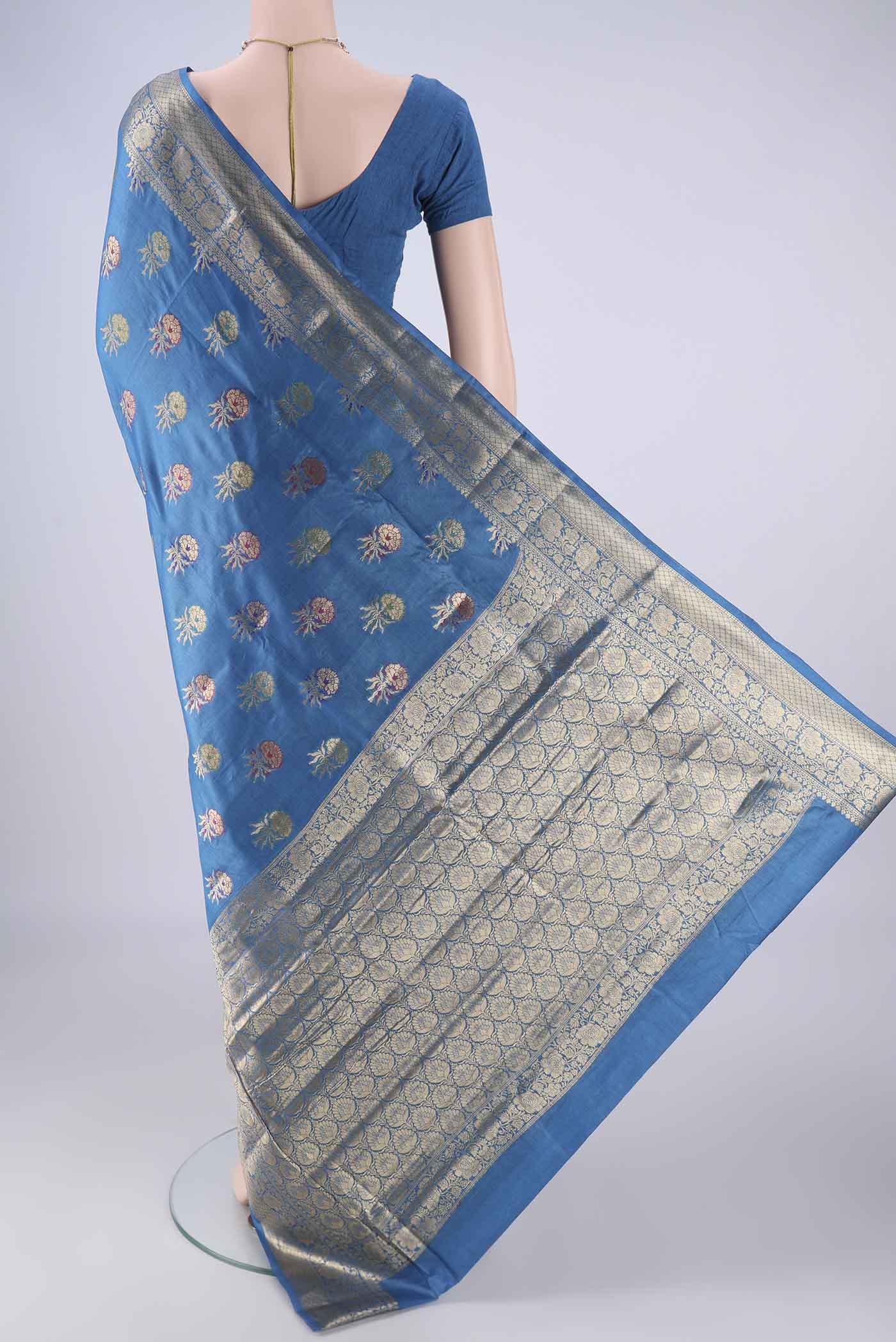 Flat view of Blue Banarasi Tussar Silk Saree with Zari And Thread Butta on the body and Zari Border. 