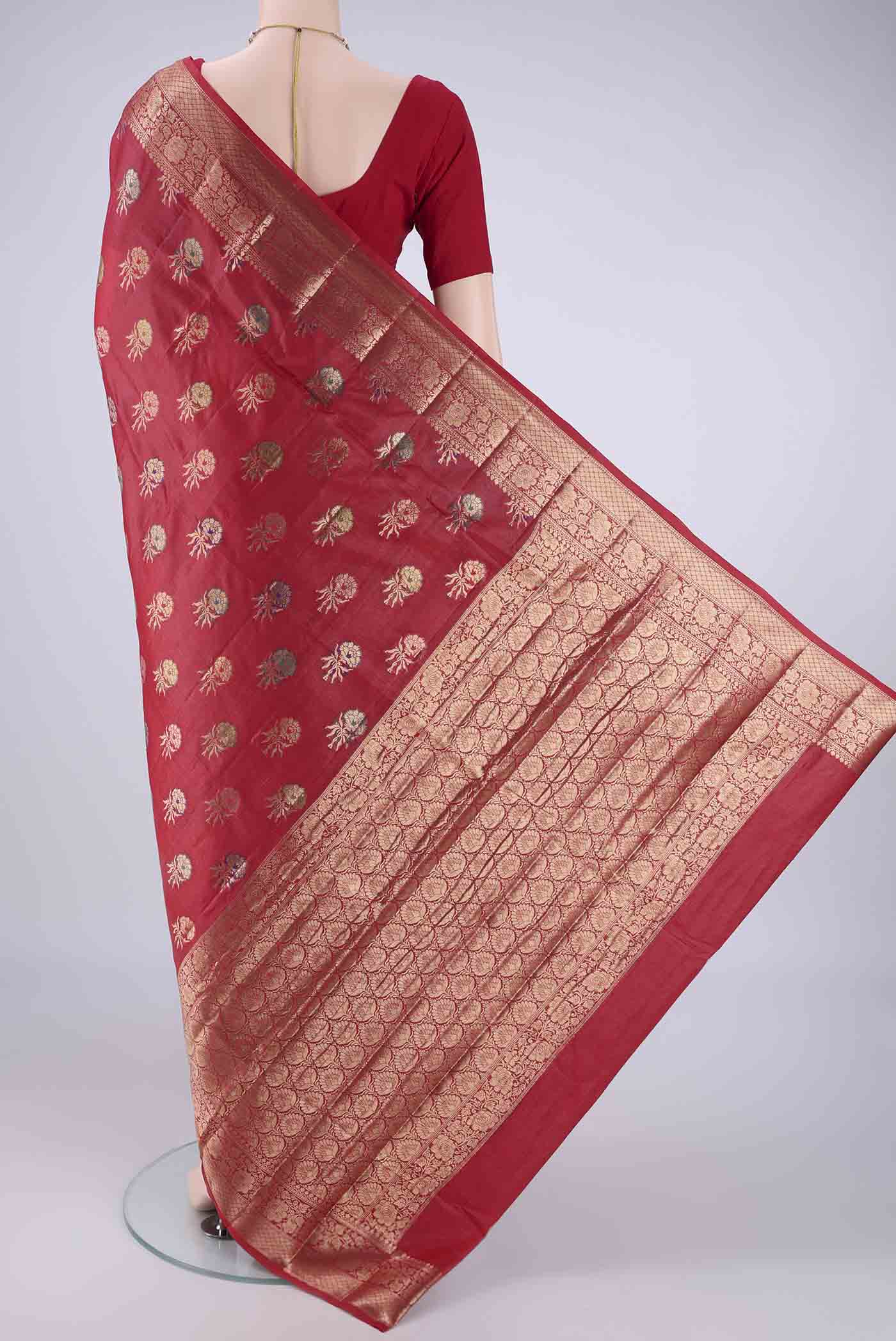 Flat view of Red Banarasi Tussar Silk Saree with Zari And Thread Butta on the body and Zari Border. 