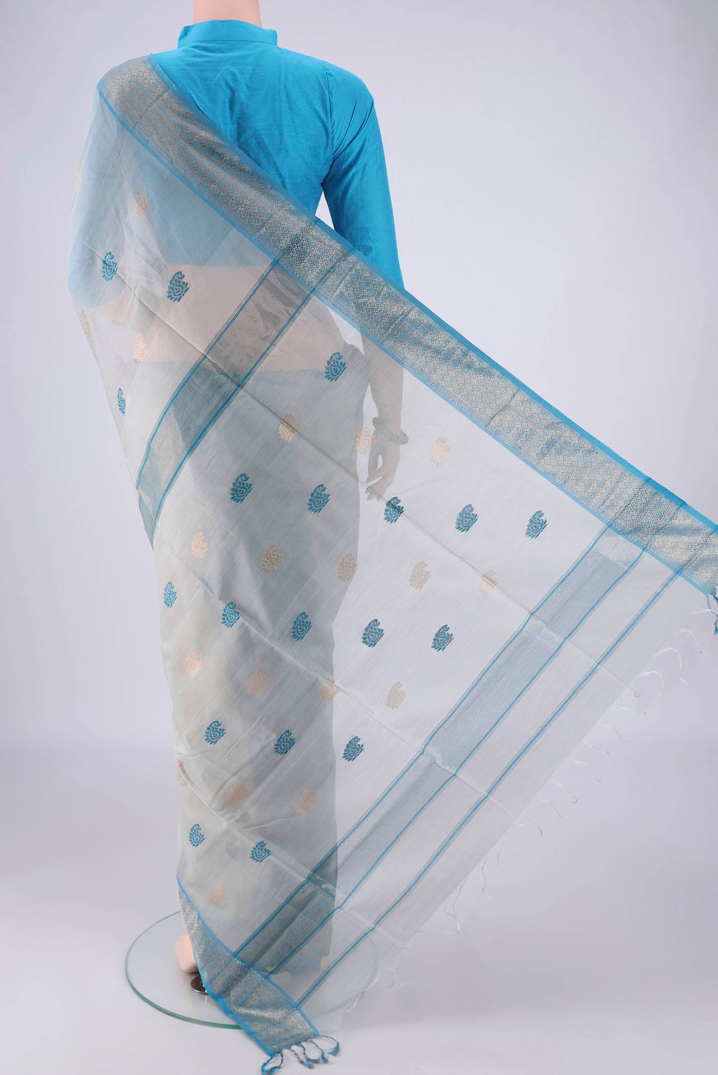 Flat view of Blue Grey Maheshwari Silk Cotton Saree with Zari And Thread Butta on the body and Zari Border. 