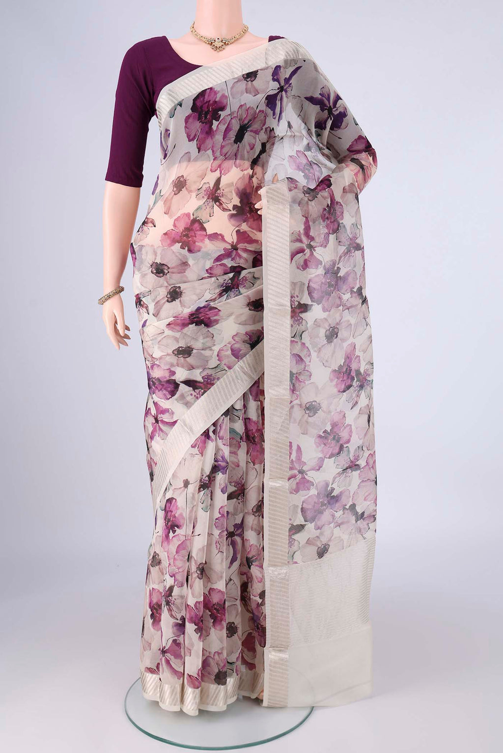 Off White Organza Silk Saree with Printed design on the body and Zari Border.  displayed on a mannequin