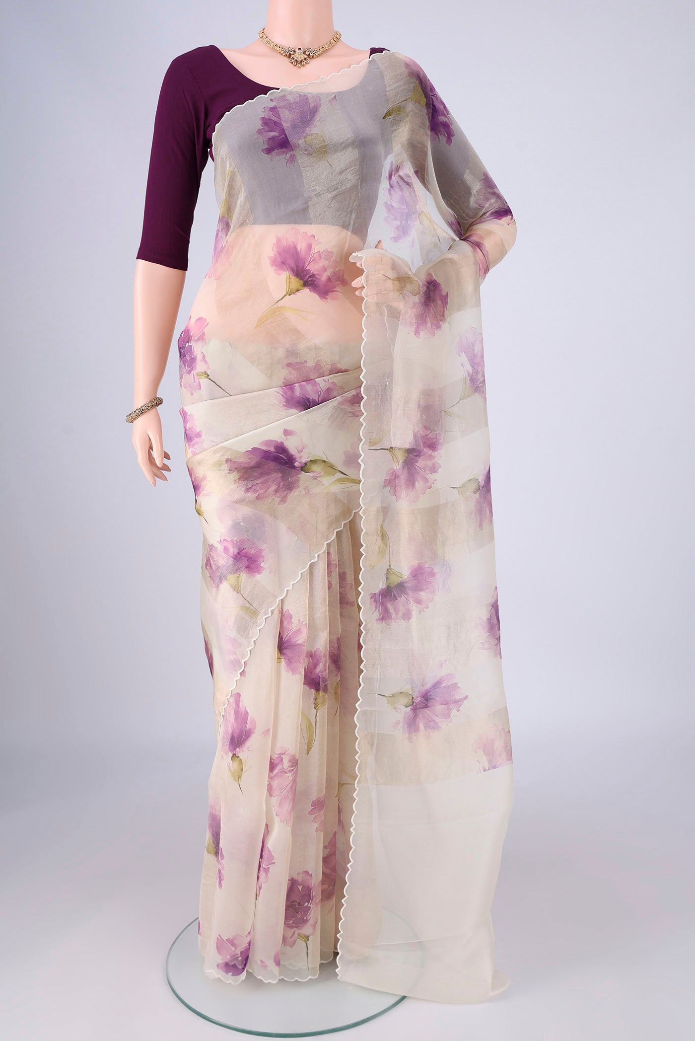Off White Organza Silk Saree with Printed design on the body and Fancy Border.  displayed on a mannequin