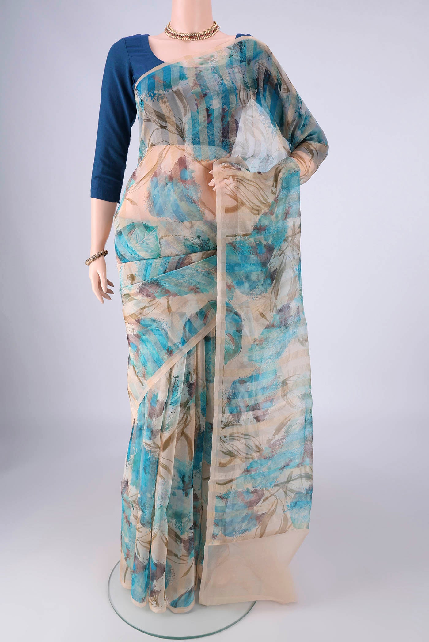 Beige Organza Silk Saree with Printed design on the body and Without Border.  displayed on a mannequin
