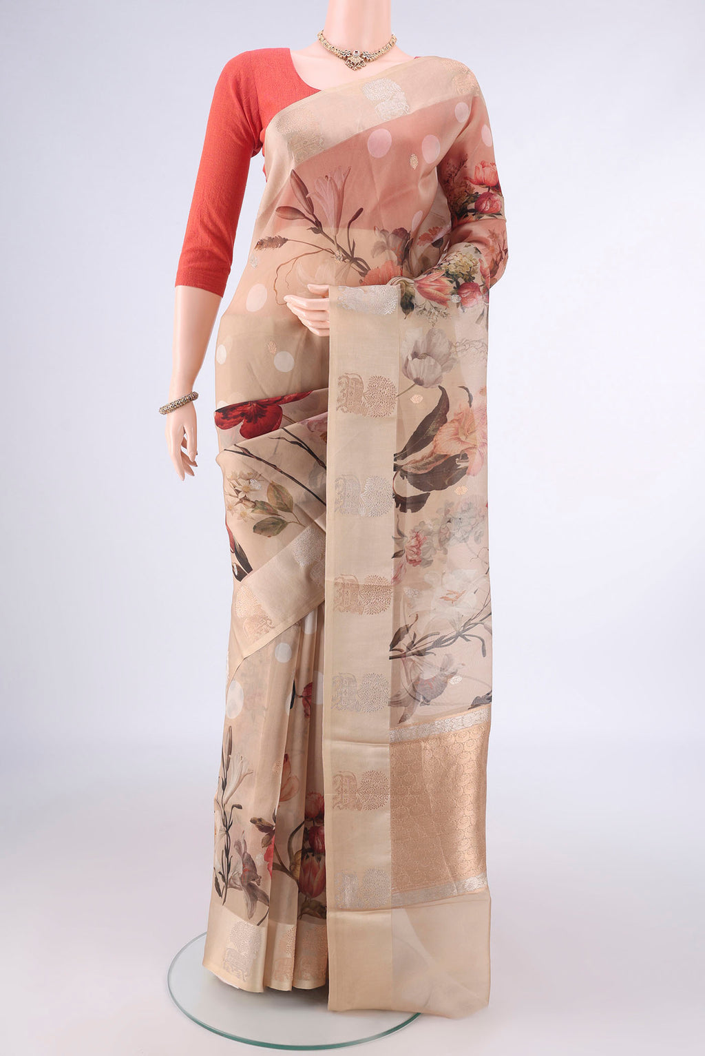 Beige Organza Saree with Zari Butta on the body and Satin Border.  displayed on a mannequin