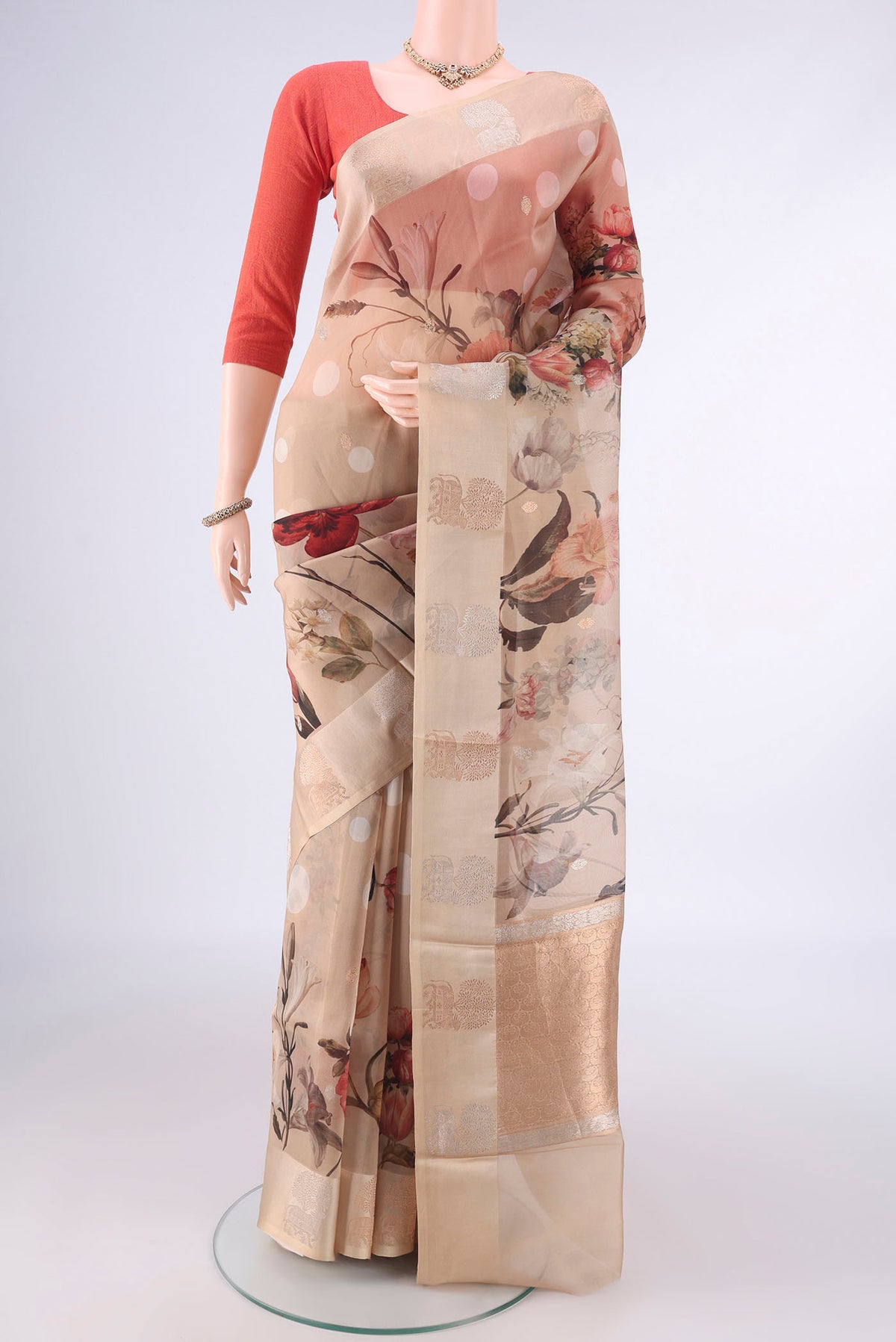 Beige Organza Saree with Zari Butta on the body and Satin Border.  displayed on a mannequin