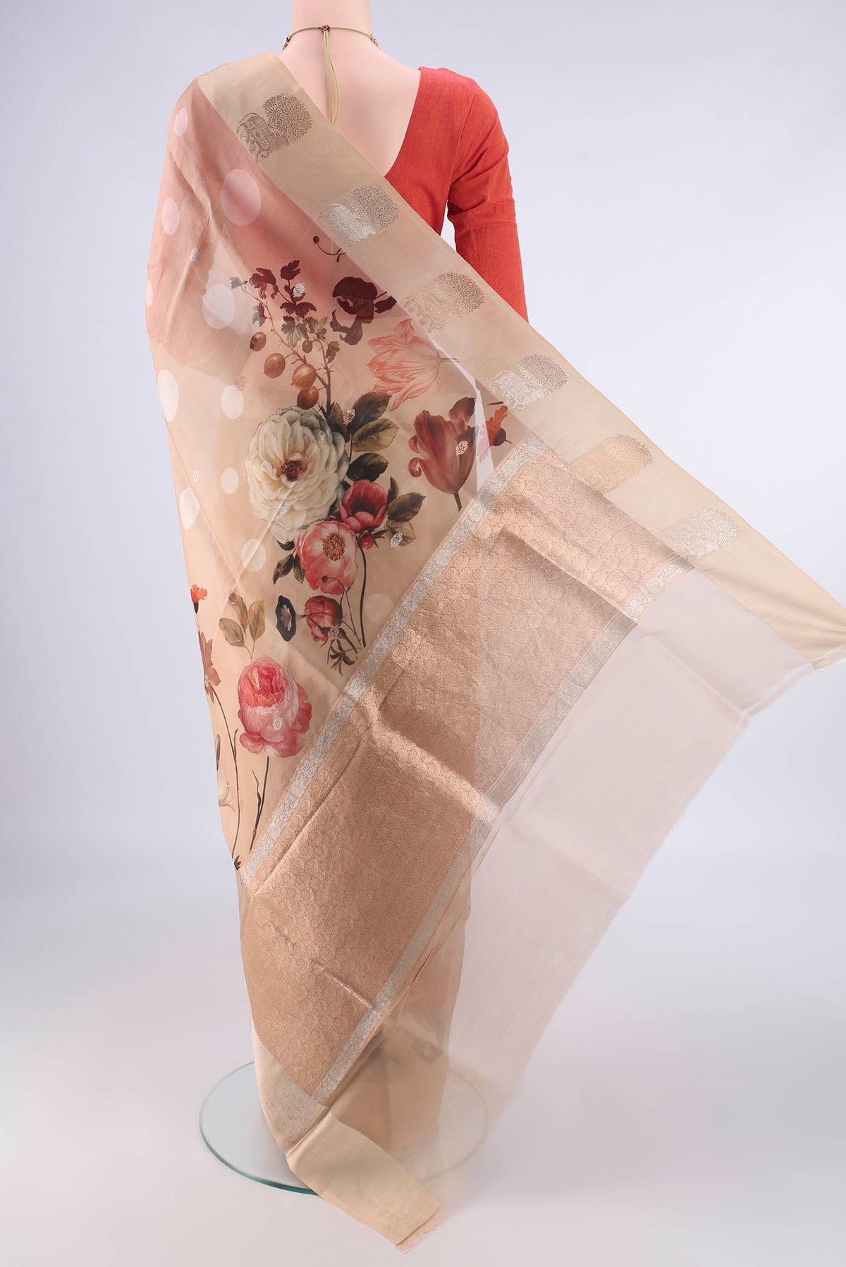 Flat view of Beige Organza Saree with Zari Butta on the body and Satin Border. 