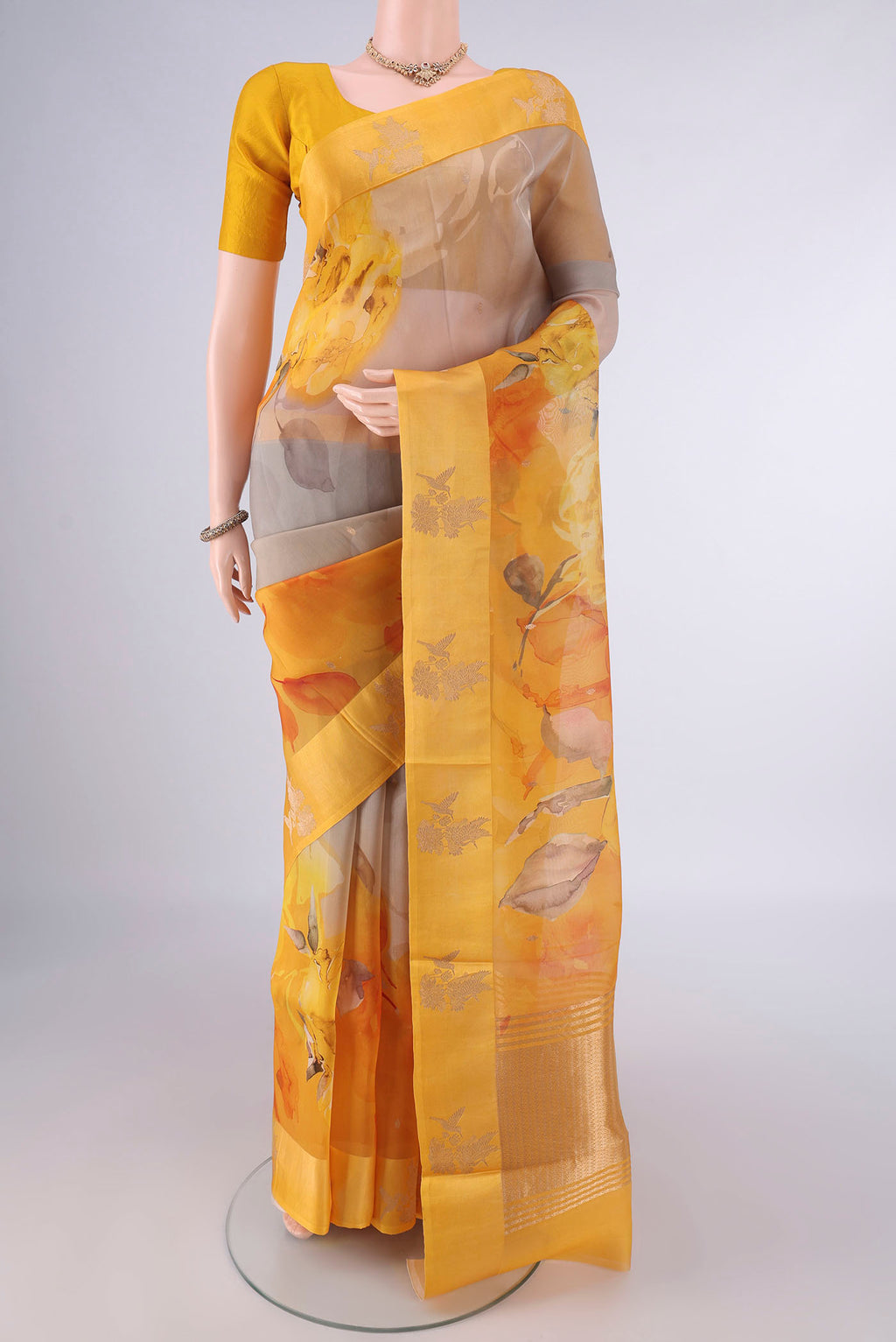 Multi Color Organza Saree with Zari Butta on the body and Satin Border.  displayed on a mannequin