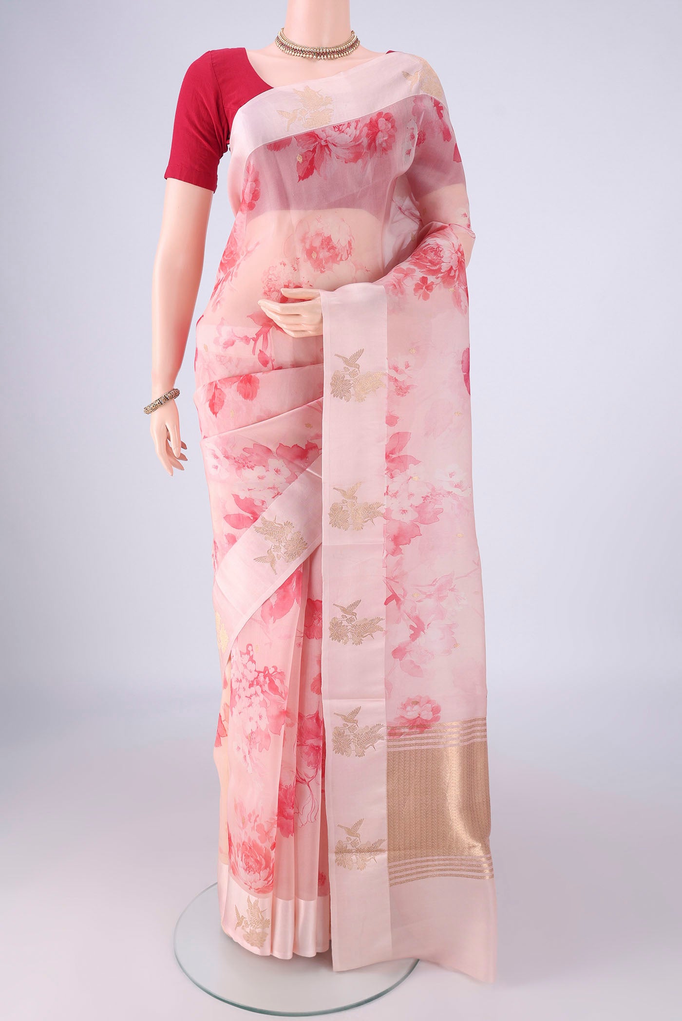 Pink Organza Silk Saree with Printed design on the body and Zari Border.  displayed on a mannequin