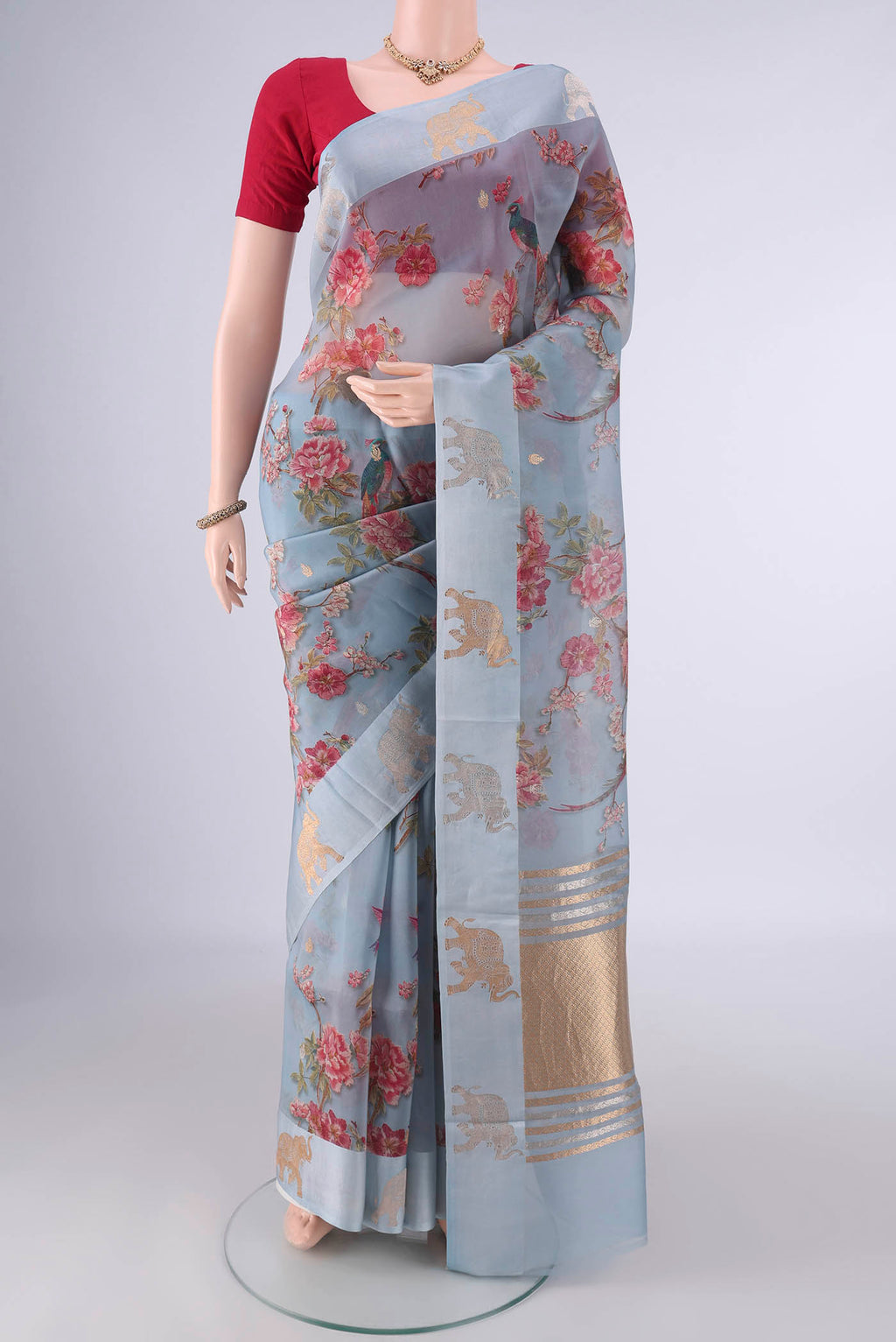 Blue Grey Organza Saree with Zari Butta on the body and Satin Border.  displayed on a mannequin