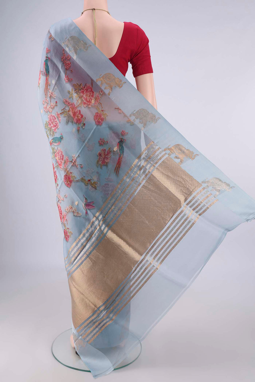 Flat view of Blue Grey Organza Saree with Zari Butta on the body and Satin Border. 