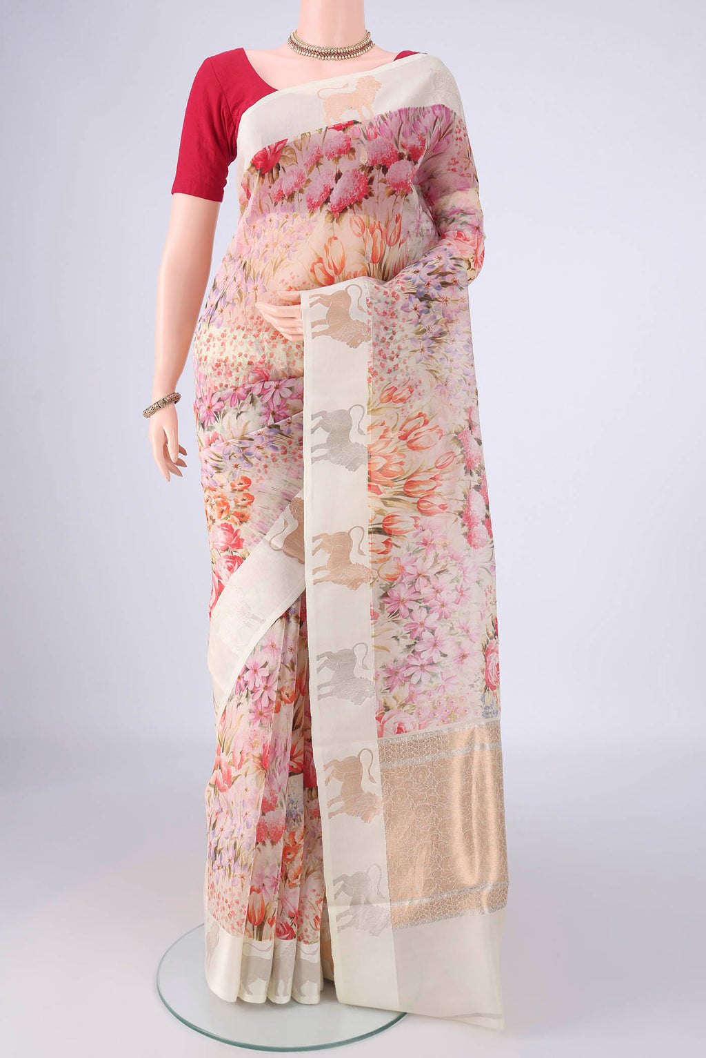 Off White Organza Silk Saree with Printed design on the body and Zari Border.  displayed on a mannequin