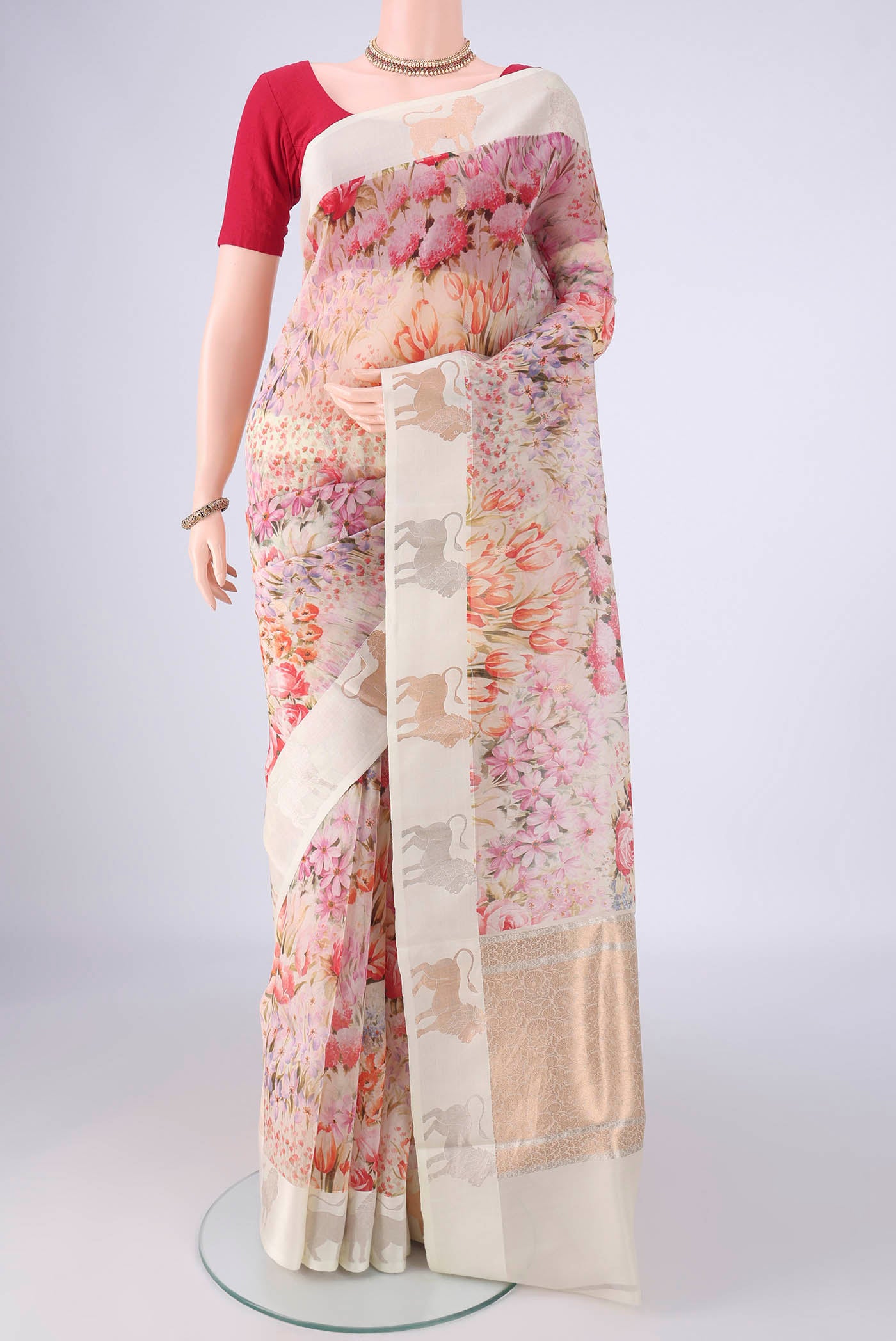 Off White Organza Silk Saree with Printed design on the body and Zari Border.  displayed on a mannequin