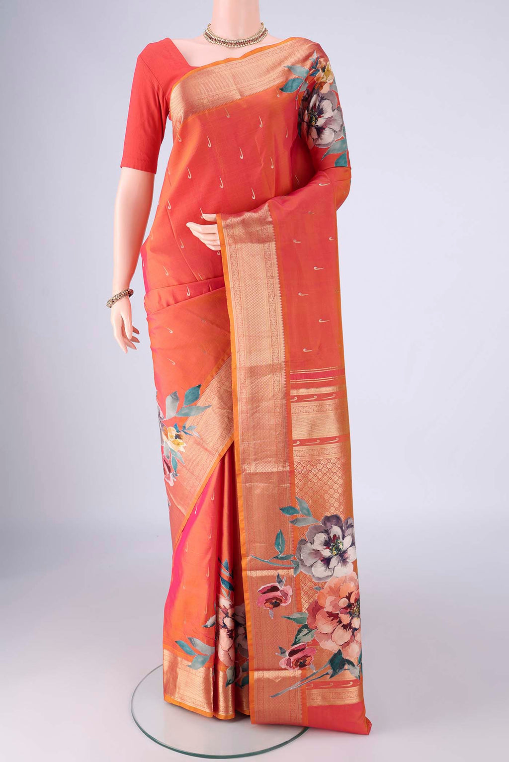 Orange Kanjivaram Silk Saree with Zari Butta on the body and Zari Border.  displayed on a mannequin