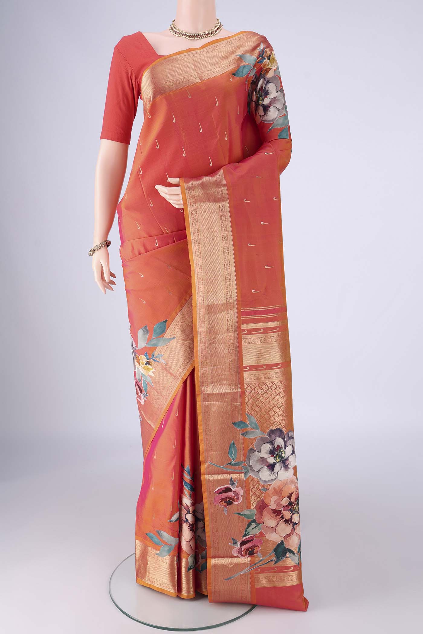 Orange Kanjivaram Silk Saree with Zari Butta on the body and Zari Border.  displayed on a mannequin
