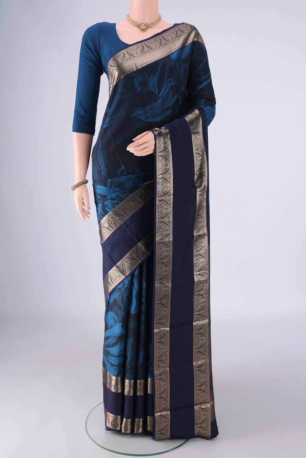 Navy Blue Kanchipuram Silk Saree with Floral Print on the body and Zari Border.  displayed on a mannequin