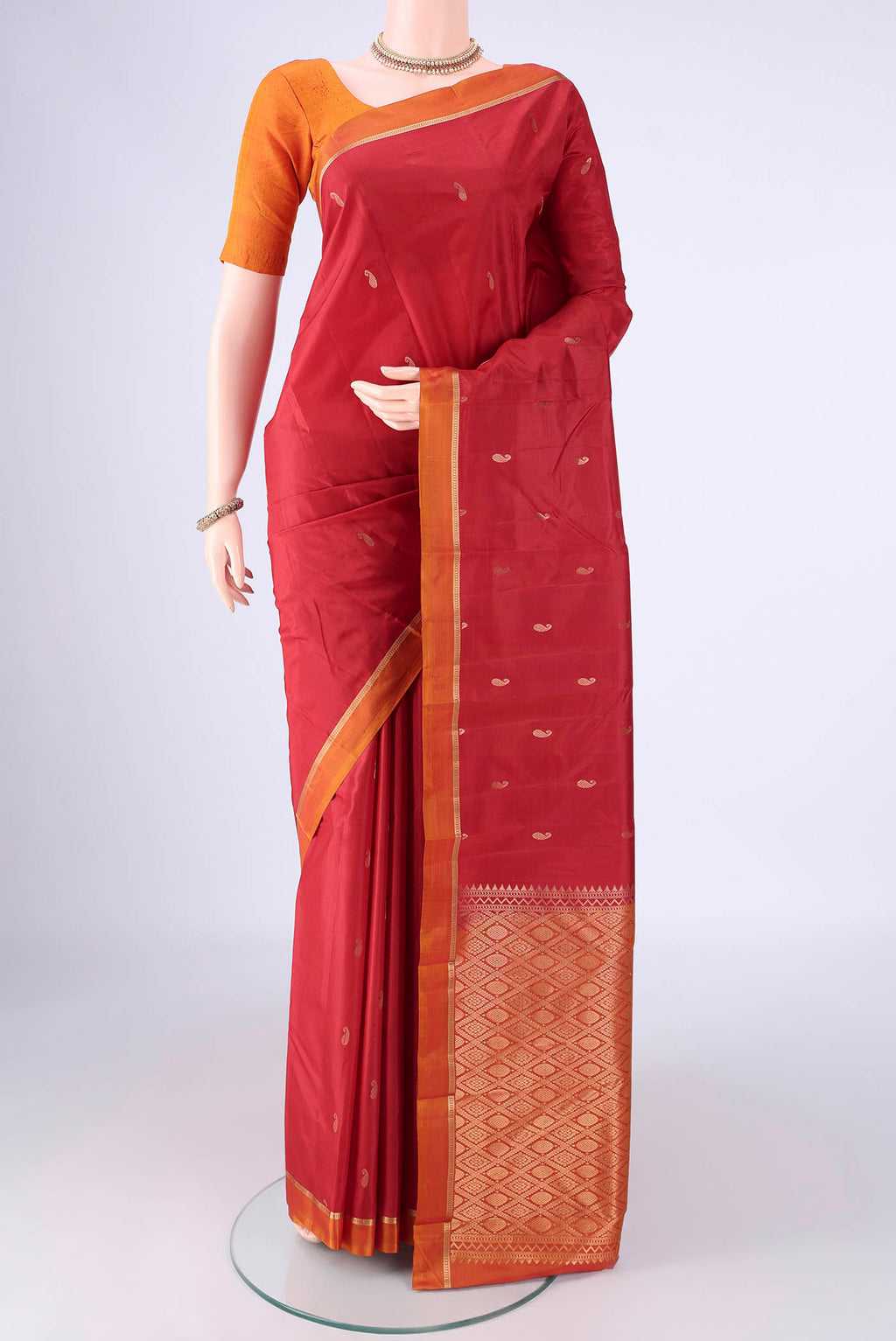 Red Kanjivaram Silk Saree with Zari Butta on the body and Plain Border.  displayed on a mannequin