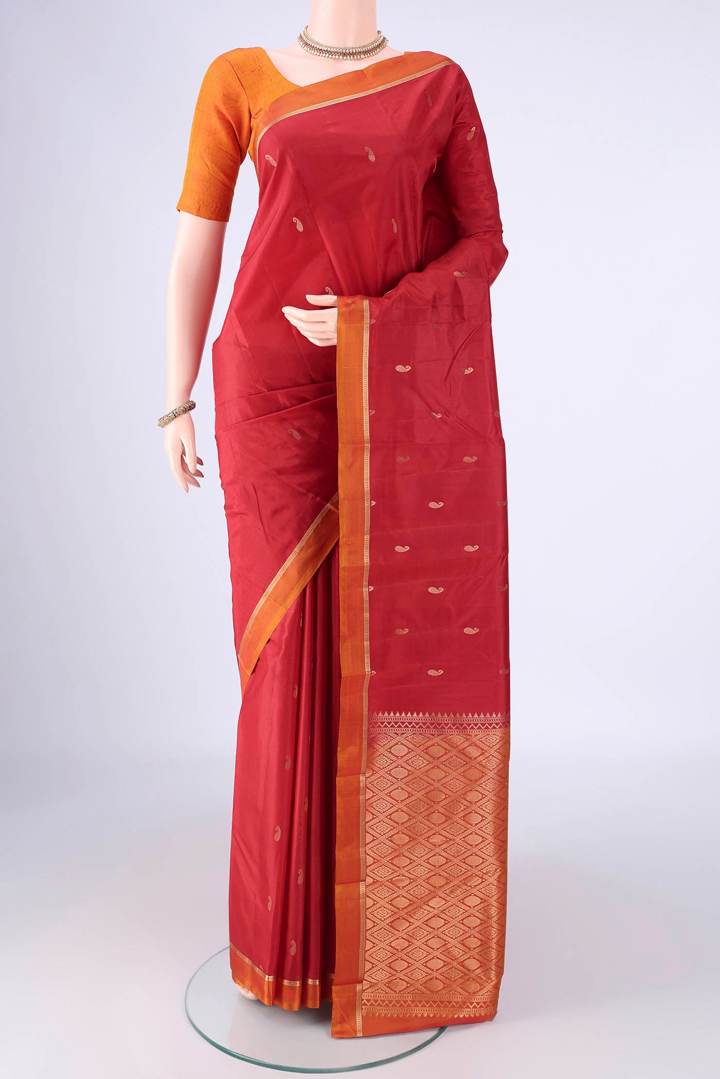 Red Kanjivaram Silk Saree with Zari Butta on the body and Plain Border.  displayed on a mannequin