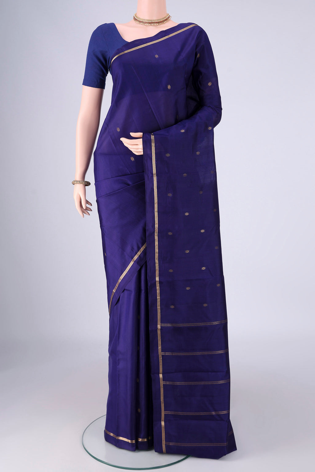 Navy Blue Kanjivaram Silk Saree with Zari Butta on the body and Thin Zari Line.  displayed on a mannequin