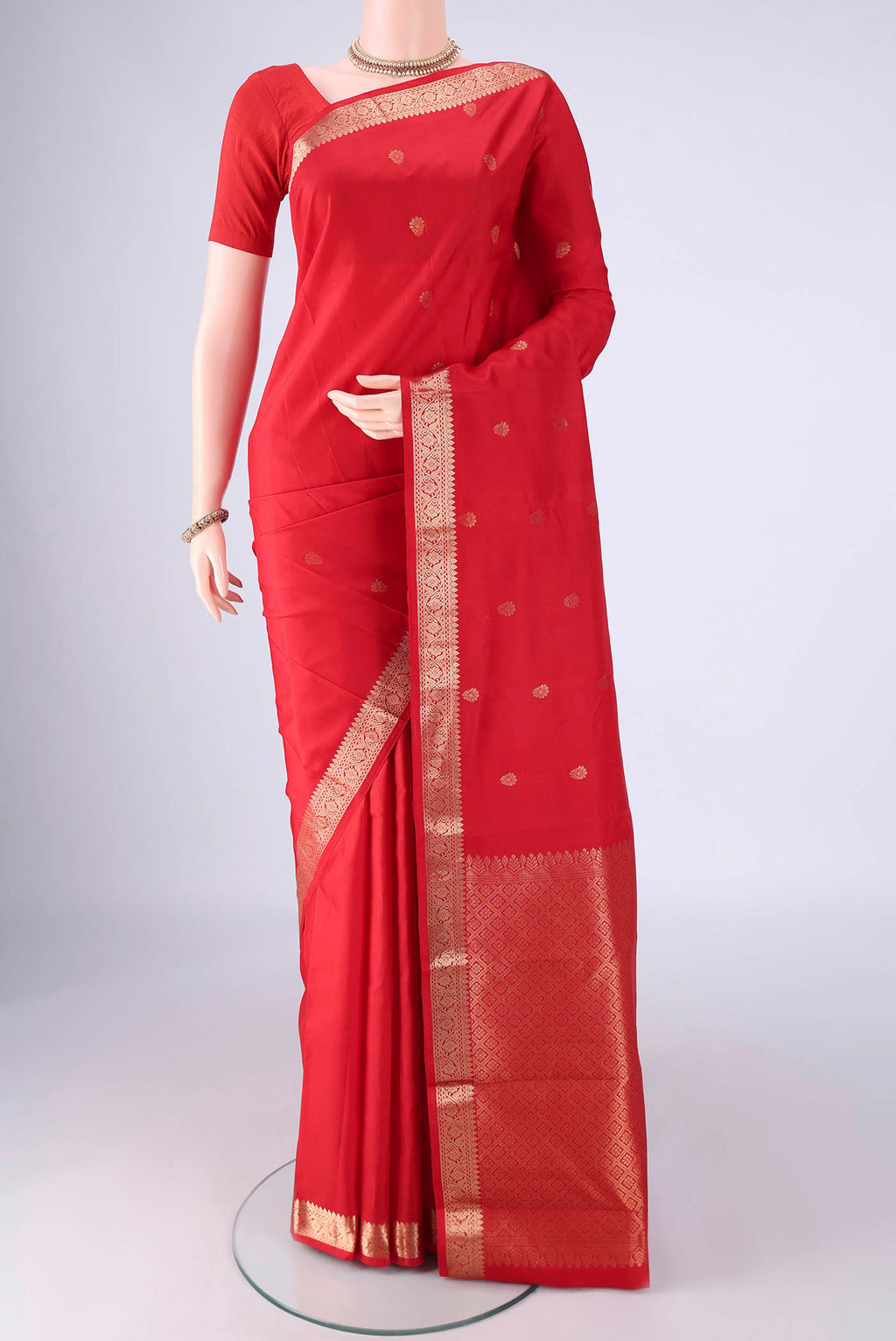 Red Kanjivaram Silk Saree with Zari Butta on the body and Zari Border.  displayed on a mannequin