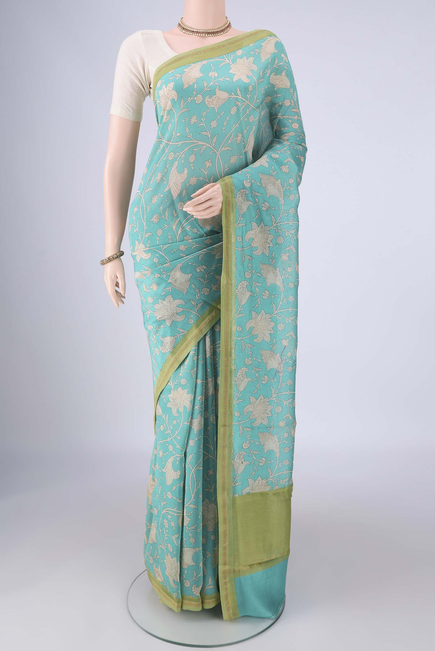 Turquoise Chanderi Silk Cotton Saree with Printed design on the body and Thin Zari Line.  displayed on a mannequin