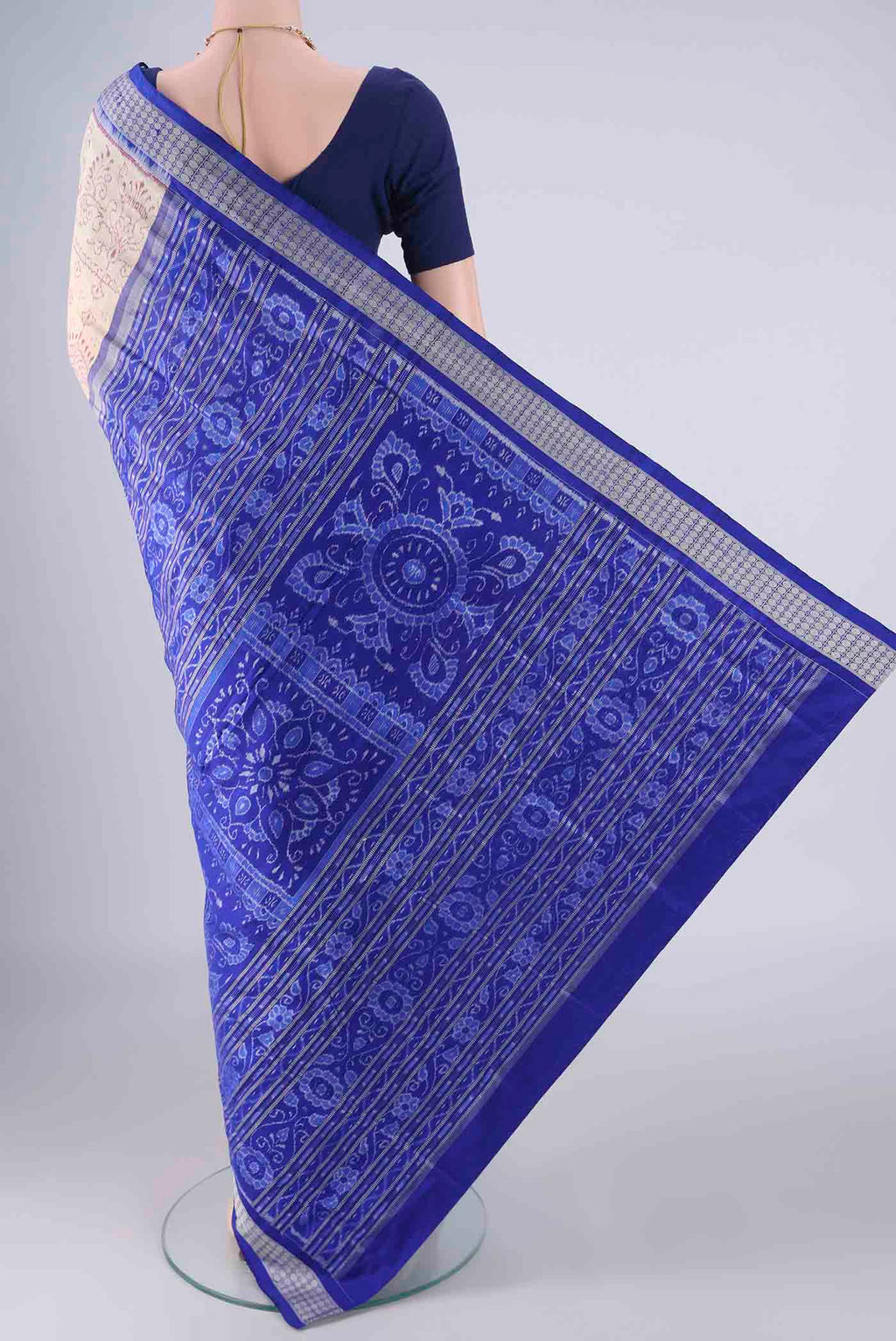 Flat view of Cream Orissa Silk Saree with Ikat design on the body and Thread Border. 