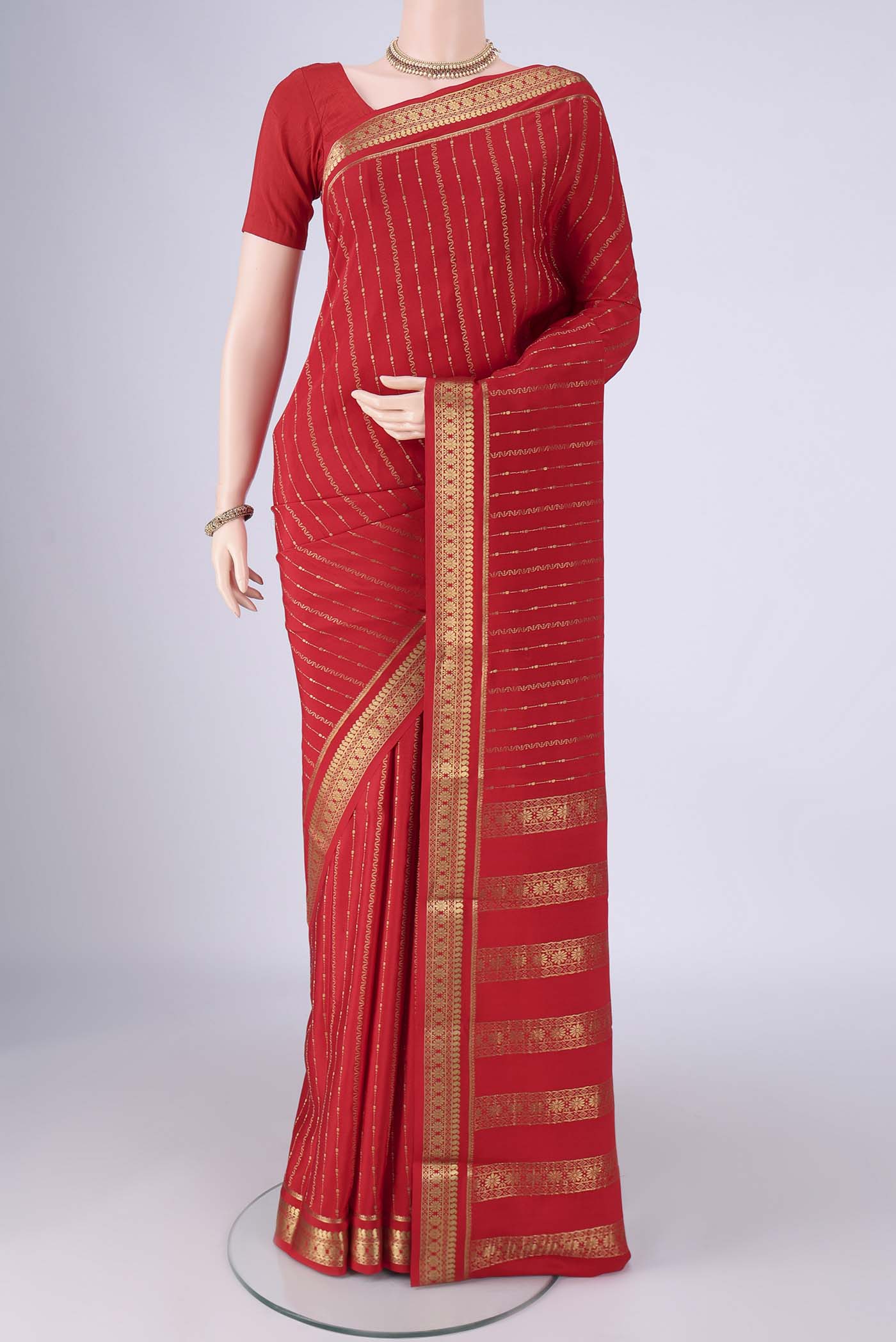 Red Mysore Crepe Saree with Stripes on the body and Zari Border.  displayed on a mannequin