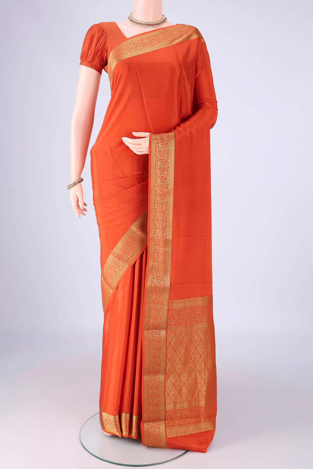 Rust Mysore Crepe Saree with Plain Body and Zari Border.  displayed on a mannequin