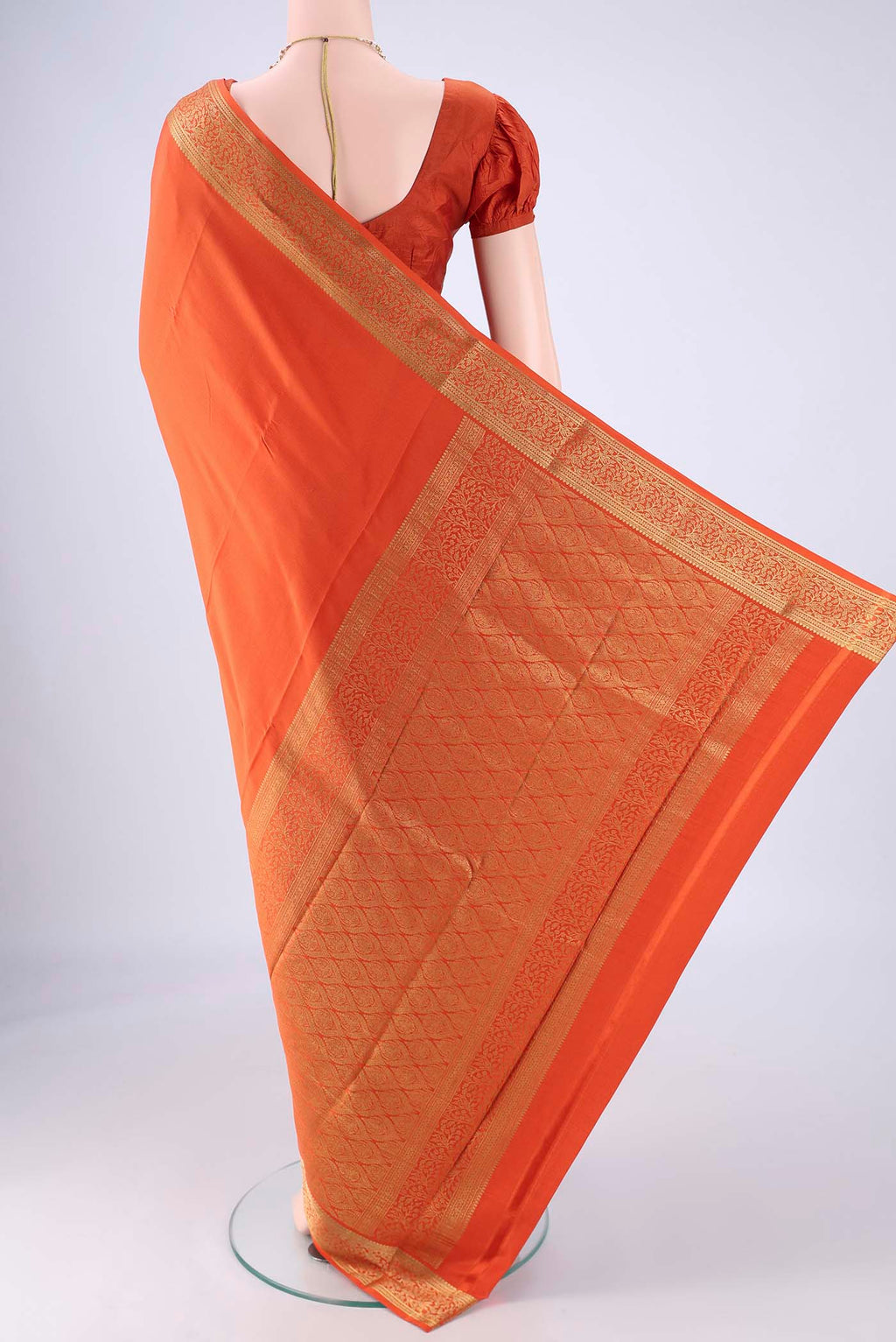 Flat view of Rust Mysore Crepe Saree with Plain Body and Zari Border. 