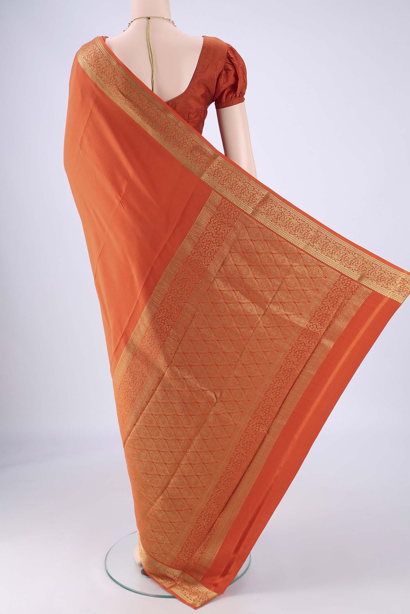 Flat view of Rust Mysore Crepe Saree with Plain Body and Zari Border. 