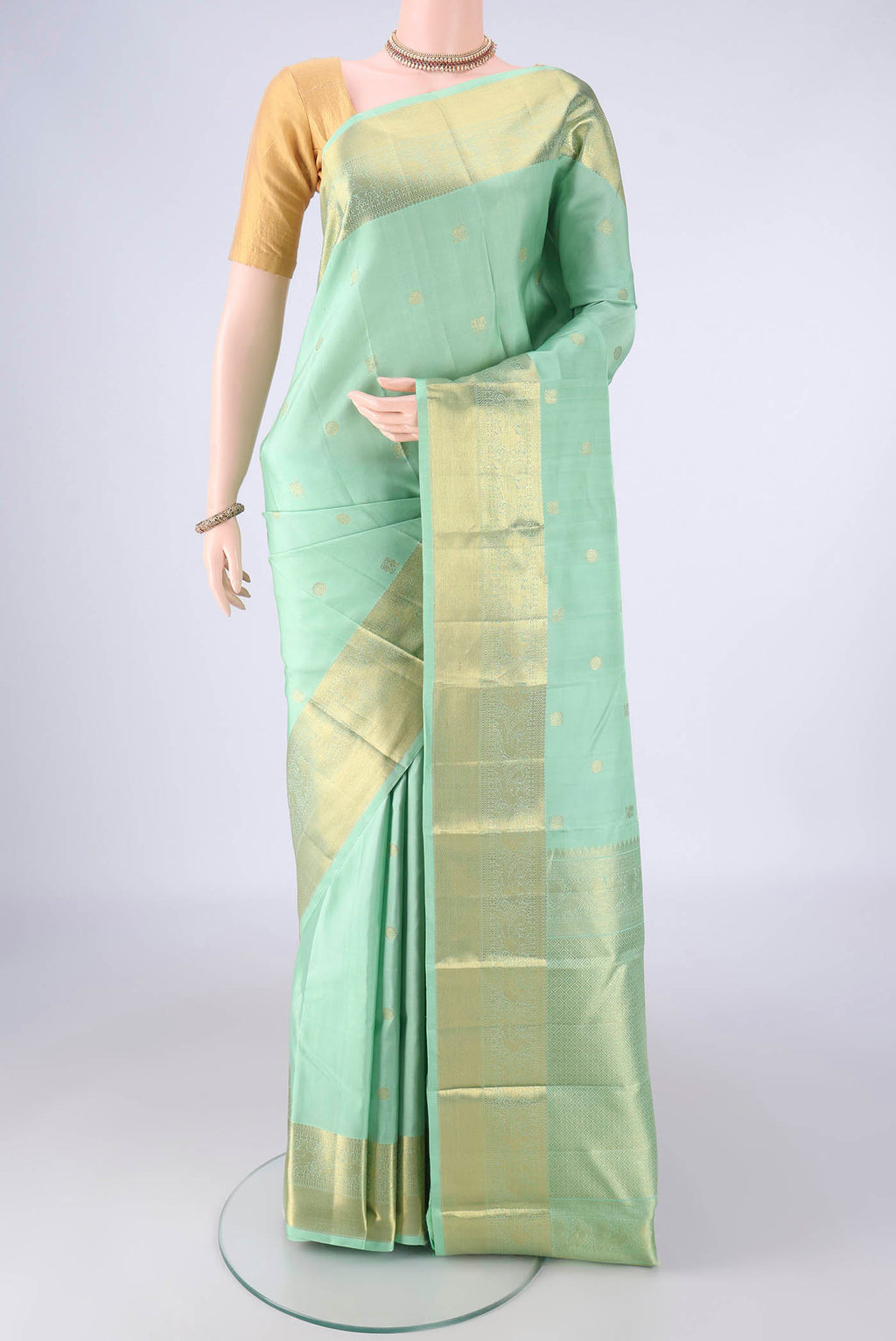 Sea Green Kanchipuram Silk Saree with Zari Butta on the body and Zari Border.  displayed on a mannequin