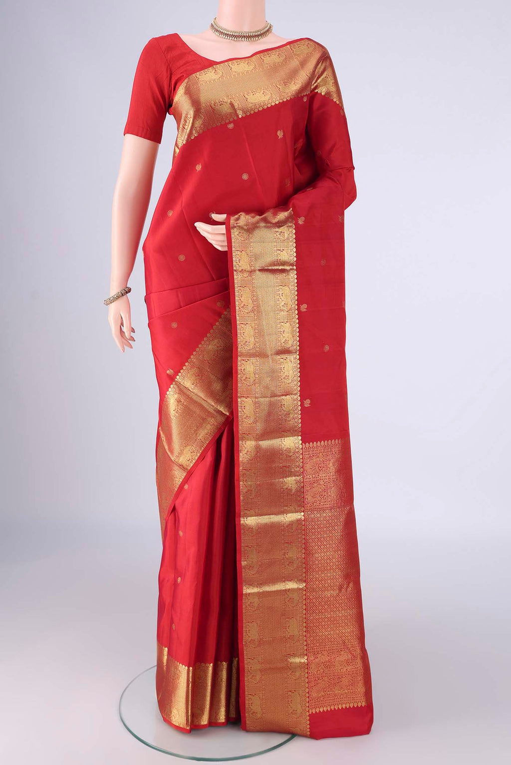 Red Kanchipuram Silk Saree with Zari Butta on the body and Zari Border.  displayed on a mannequin