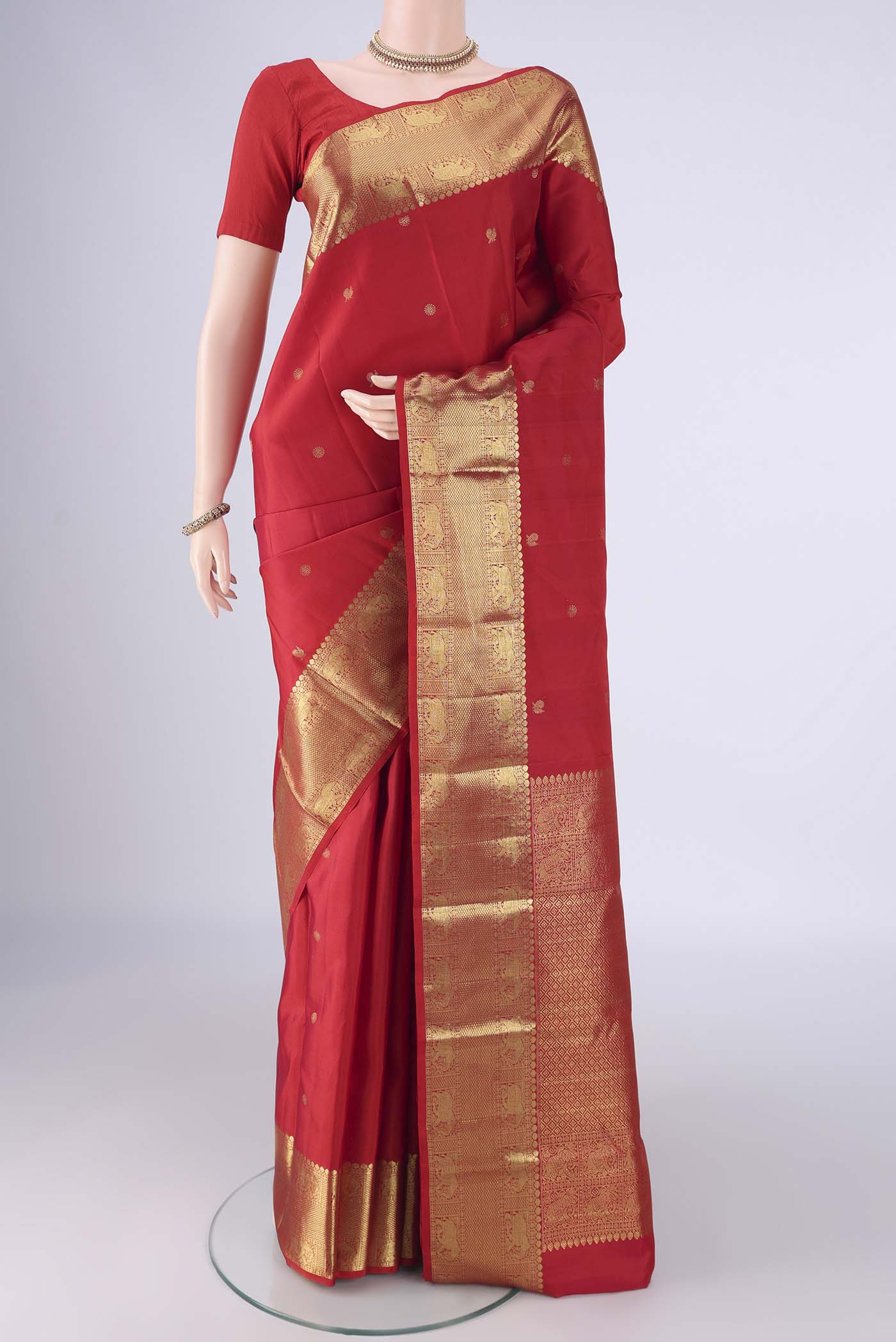 Red Kanchipuram Silk Saree with Zari Butta on the body and Zari Border.  displayed on a mannequin