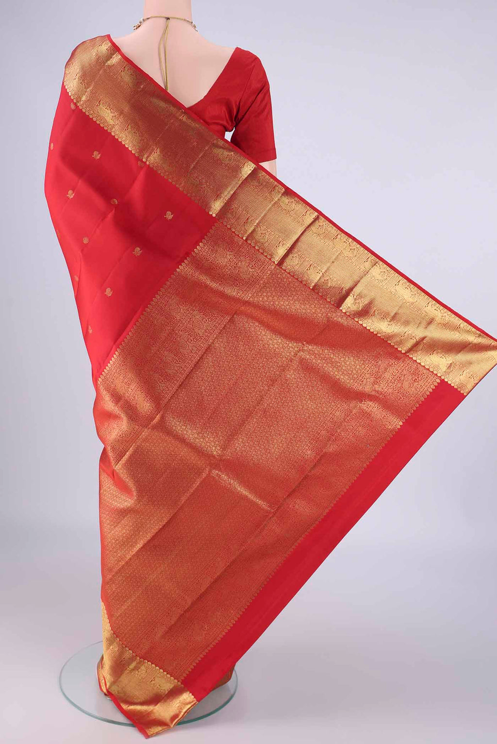 Flat view of Red Kanchipuram Silk Saree with Zari Butta on the body and Zari Border. 