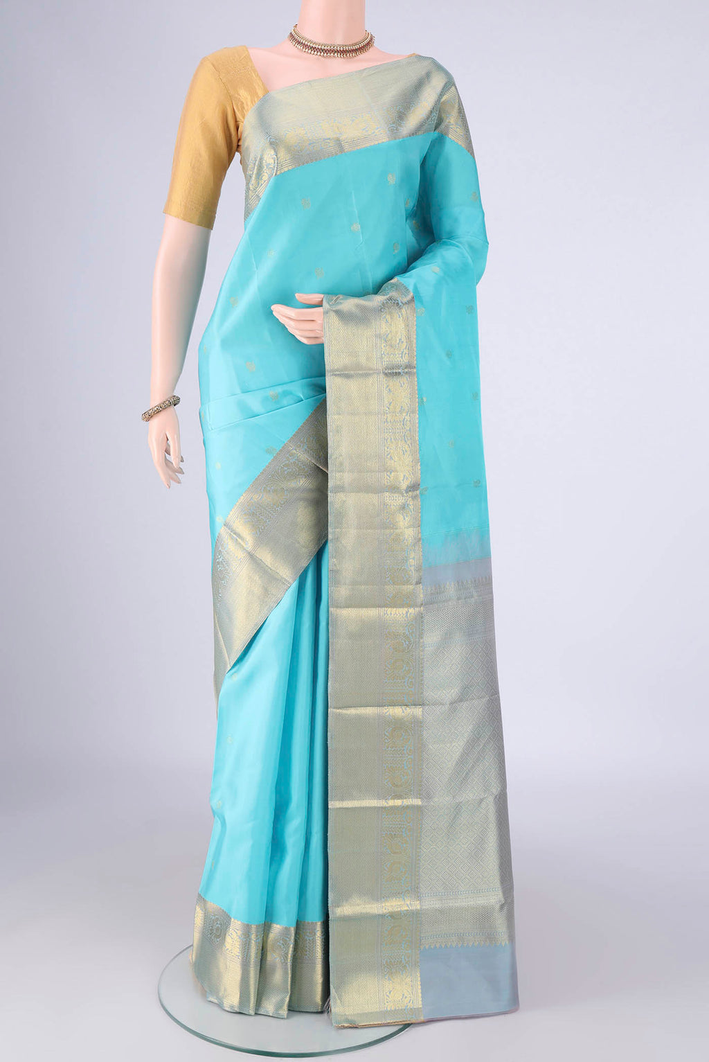 Sky Blue Kanchipuram Silk Saree with Zari Butta on the body and Zari Border.  displayed on a mannequin