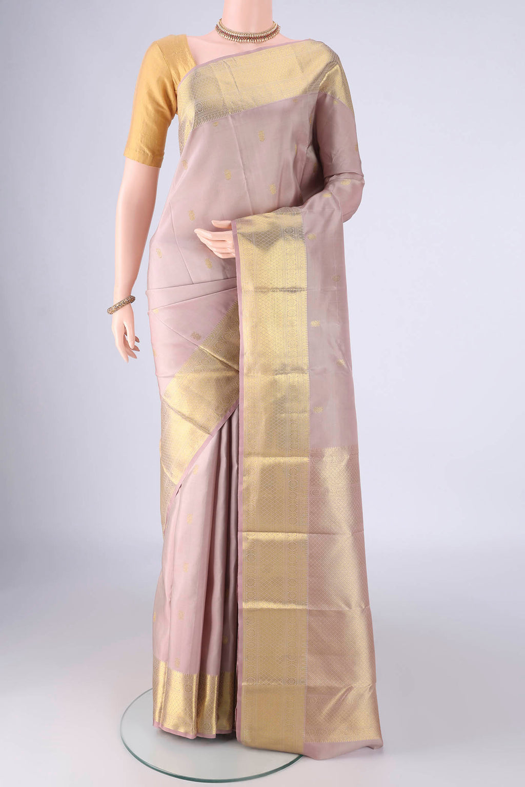 Lavender Kanchipuram Silk Saree with Zari Butta on the body and Zari Border.  displayed on a mannequin