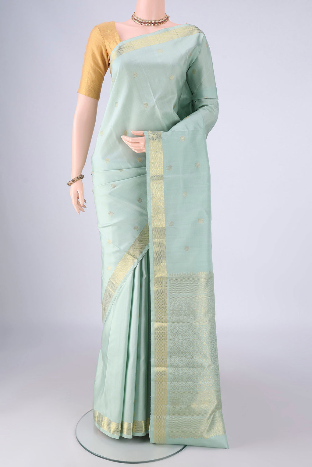 Light Blue Kanchipuram Silk Saree with Zari Butta on the body and Zari Border.  displayed on a mannequin