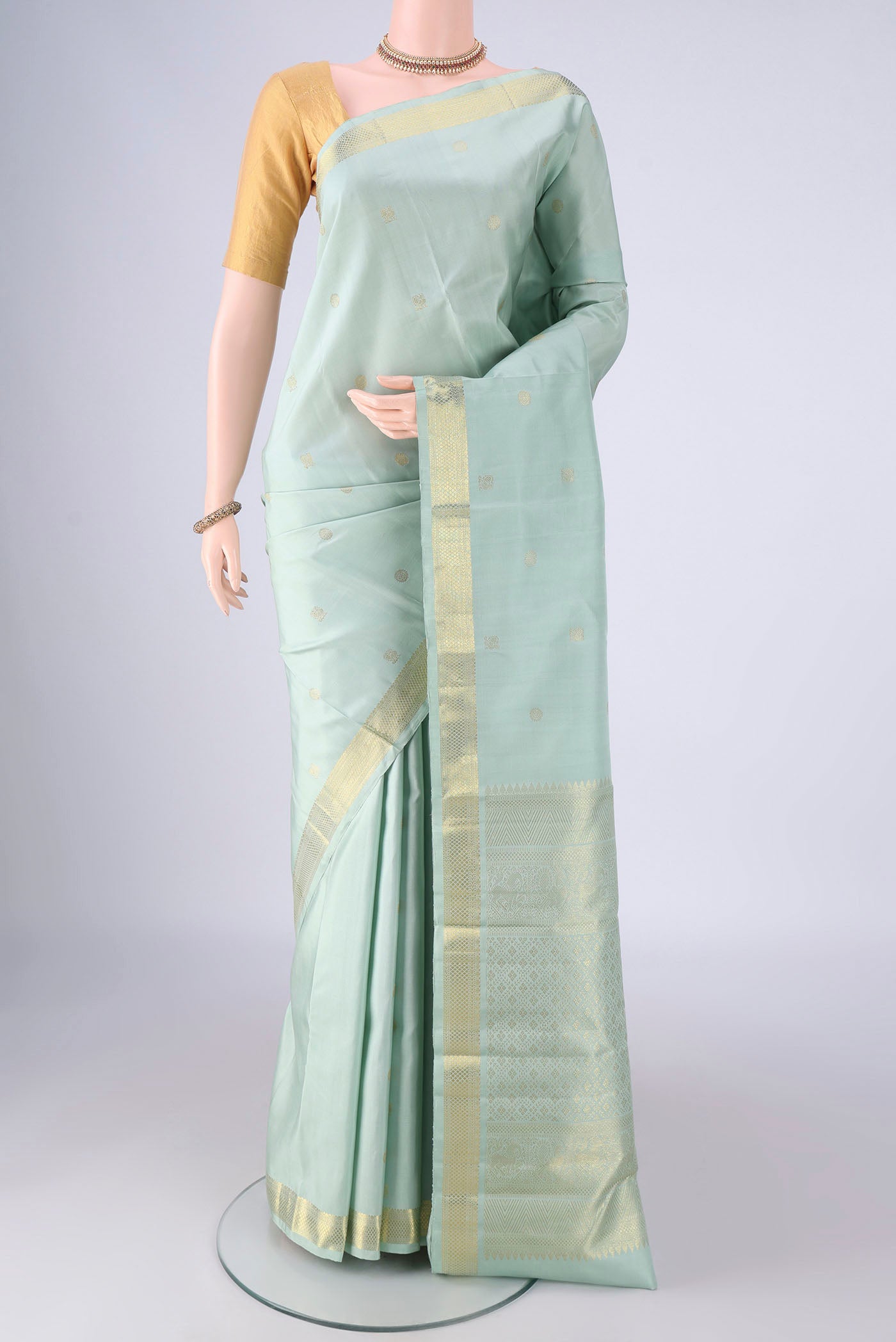 Light Blue Kanchipuram Silk Saree with Zari Butta on the body and Zari Border.  displayed on a mannequin